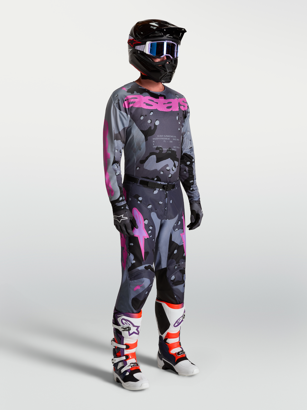 Alpinestars Racer Lone, męski zestaw motocrossowy, szary kamuflaż i fioletowe detale, koszulka, spodnie, kask oraz buty.