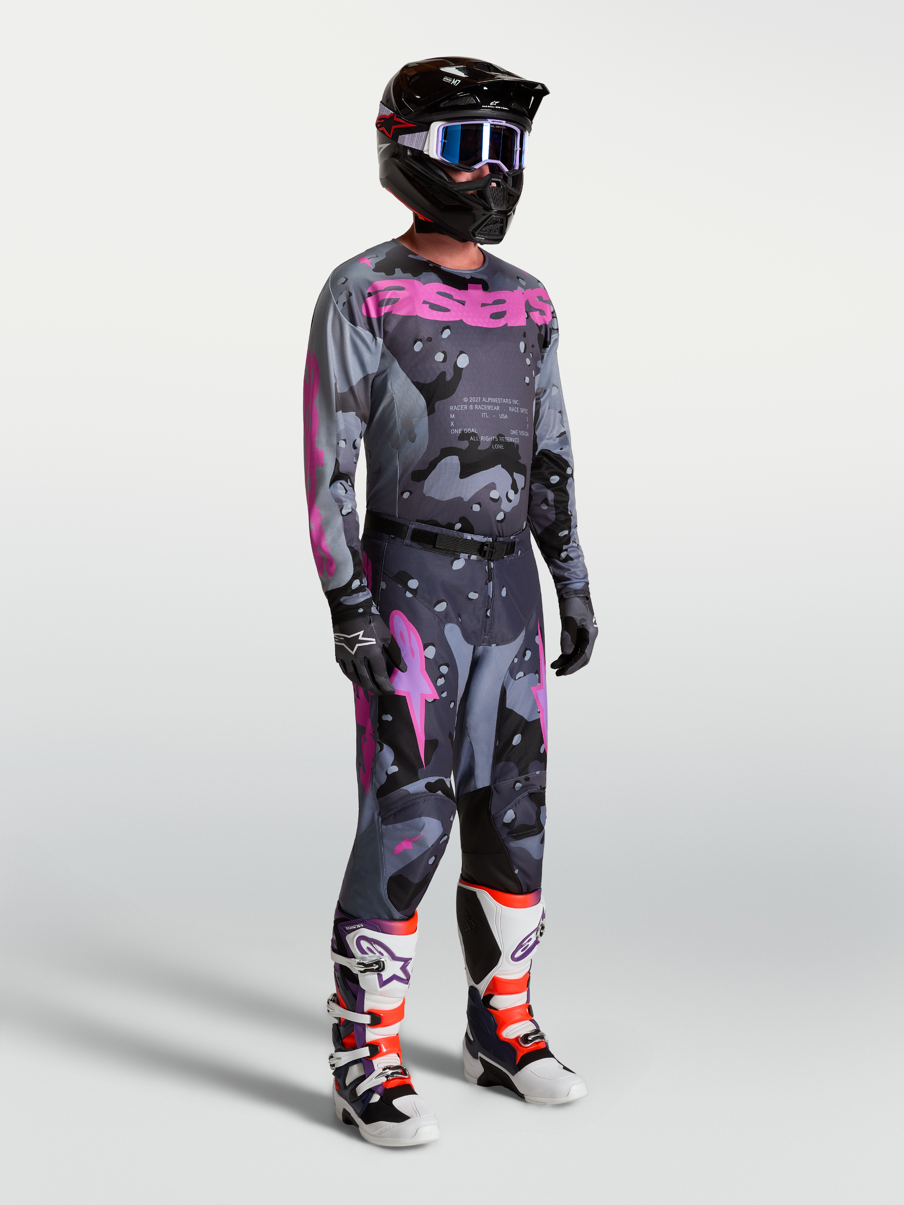 Alpinestars Racer Lone, męski zestaw motocrossowy, szary kamuflaż i fioletowe detale, koszulka, spodnie, kask oraz buty.