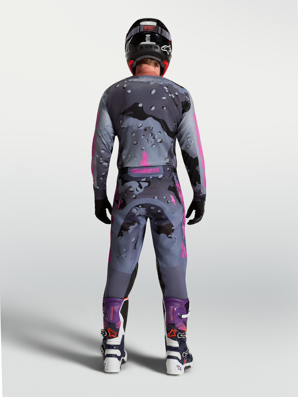 Alpinestars Racer Lone Gear Set, męski szaro-fioletowy strój motocrossowy w kamuflażu, widok z tyłu na zawodnika.