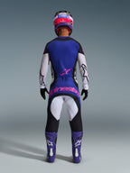 Widok z tyłu zawodnika motocrossowego ubranego w koszulkę Alpinestars 2026 Techstar Knif w kolorach czarnym, jasnoszarym i fioletowym, z białymi rękawami i różowym logo w dolnej części pleców. W komplecie z pasującymi spodniami motocrossowymi, fioletowymi butami i kolorowym kaskiem w studio.