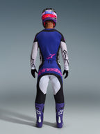 Zawodnik motocrossowy widziany od tyłu w koszulce 2026 Techstar Knif, kolor Black Light Gray Purple, pasujące spodnie motocrossowe z różowym logotypem, fioletowe buty i kask, profesjonalny, wysokowydajny zestaw odzieży off-road