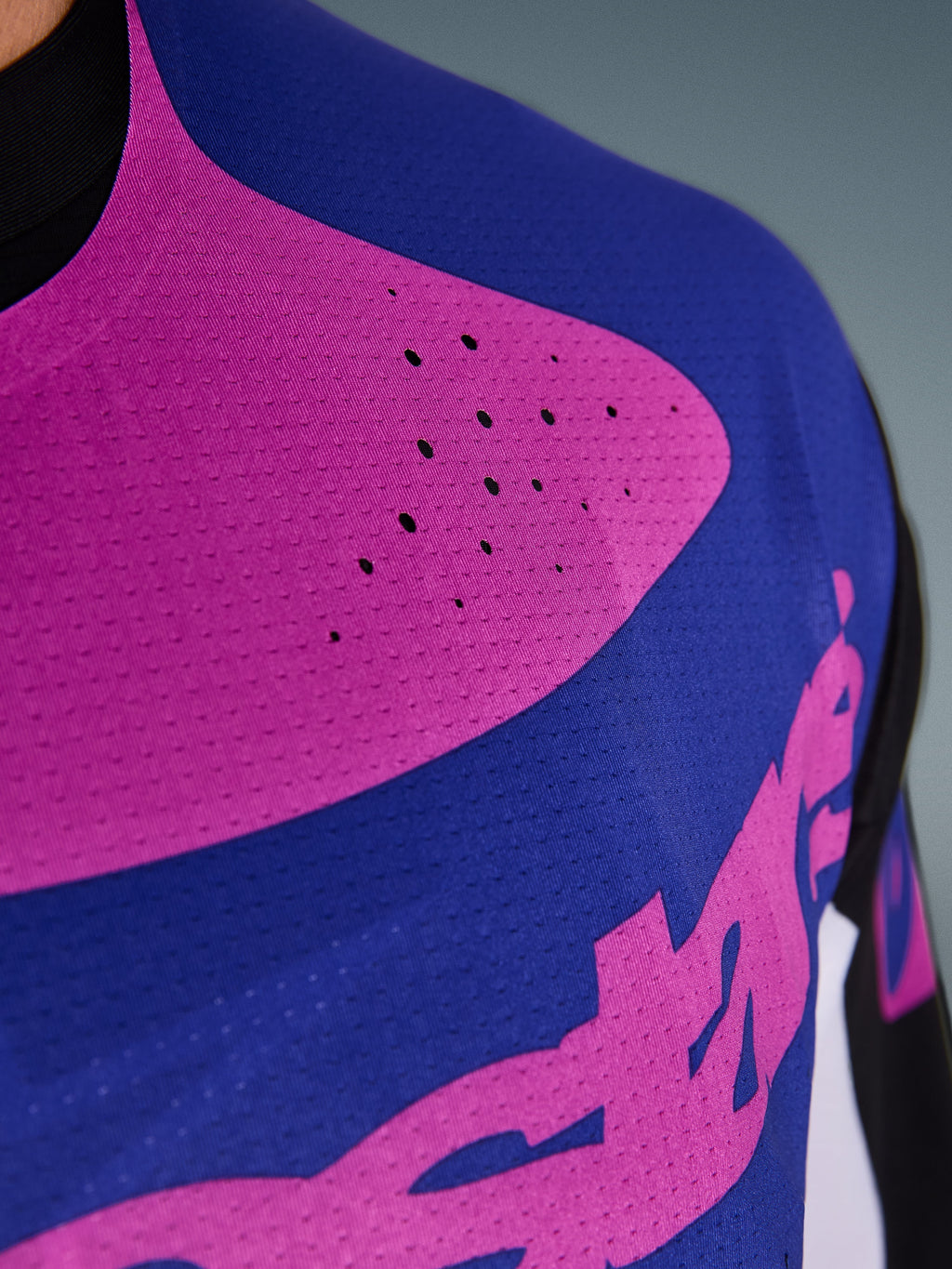Alpinestars 2026 Techstar Knif Jersey, koszulka motocrossowa, czarna, jasnoszara i fioletowa, zbliżenie na klatkę piersiową z laserowo wycinanymi perforacjami i odprowadzającym wilgoć elastycznym materiałem dla lepszej wentylacji