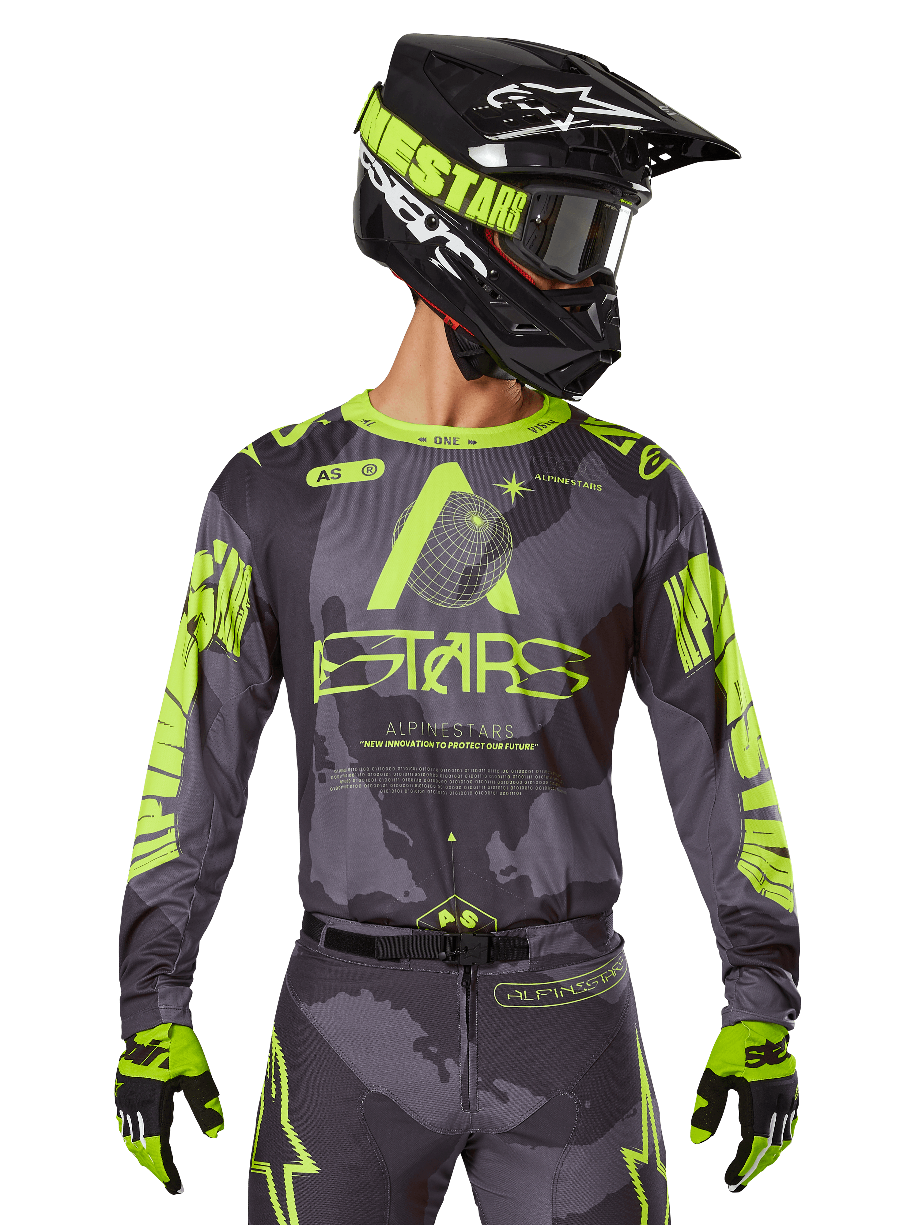 Alpinestars 2025 Racer Hollow Jersey, koszulka motocrossowa, ciemne moro i neonowy żółty, noszona z dopasowanymi spodniami, czarno-żółtym kaskiem z goglami i czarnymi rękawicami, logo Alpinestars i wzór kamuflażu