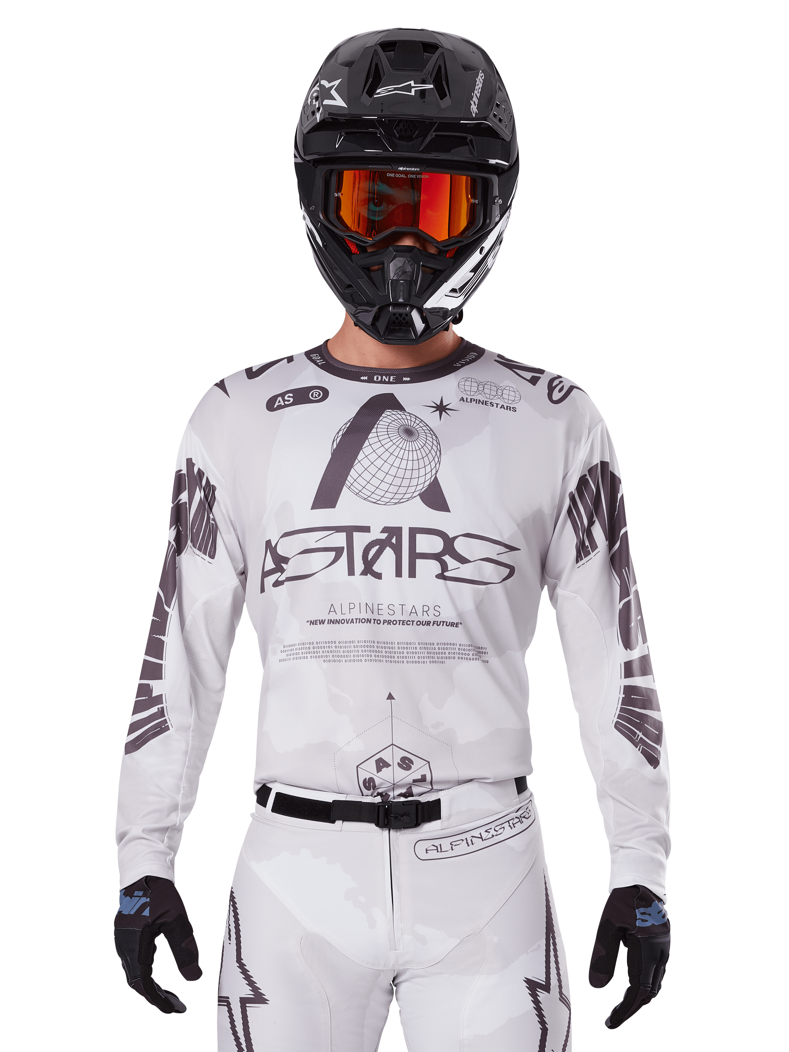 Alpinestars 2025 Racer Hollow Jersey, biało-czarna koszulka motocrossowa, noszona z pasującymi białymi spodniami MX i czarnym kaskiem z pomarańczowymi goglami, z wyraźnym brandingiem Alpinestars i grafikami z motywem globu, profesjonalna odzież wyścigowa off-road