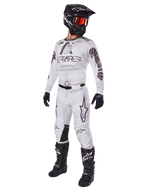 Alpinestars 2025 Racer Hollow Gear Set, strój motocrossowy, biało-szary, koszulka i spodnie z wyraźnym brandingiem „STARS”, czarny kask z pomarańczowo-czerwonymi goglami, czarne rękawice i czarne buty, kompletny profesjonalny sprzęt do jazdy terenowej