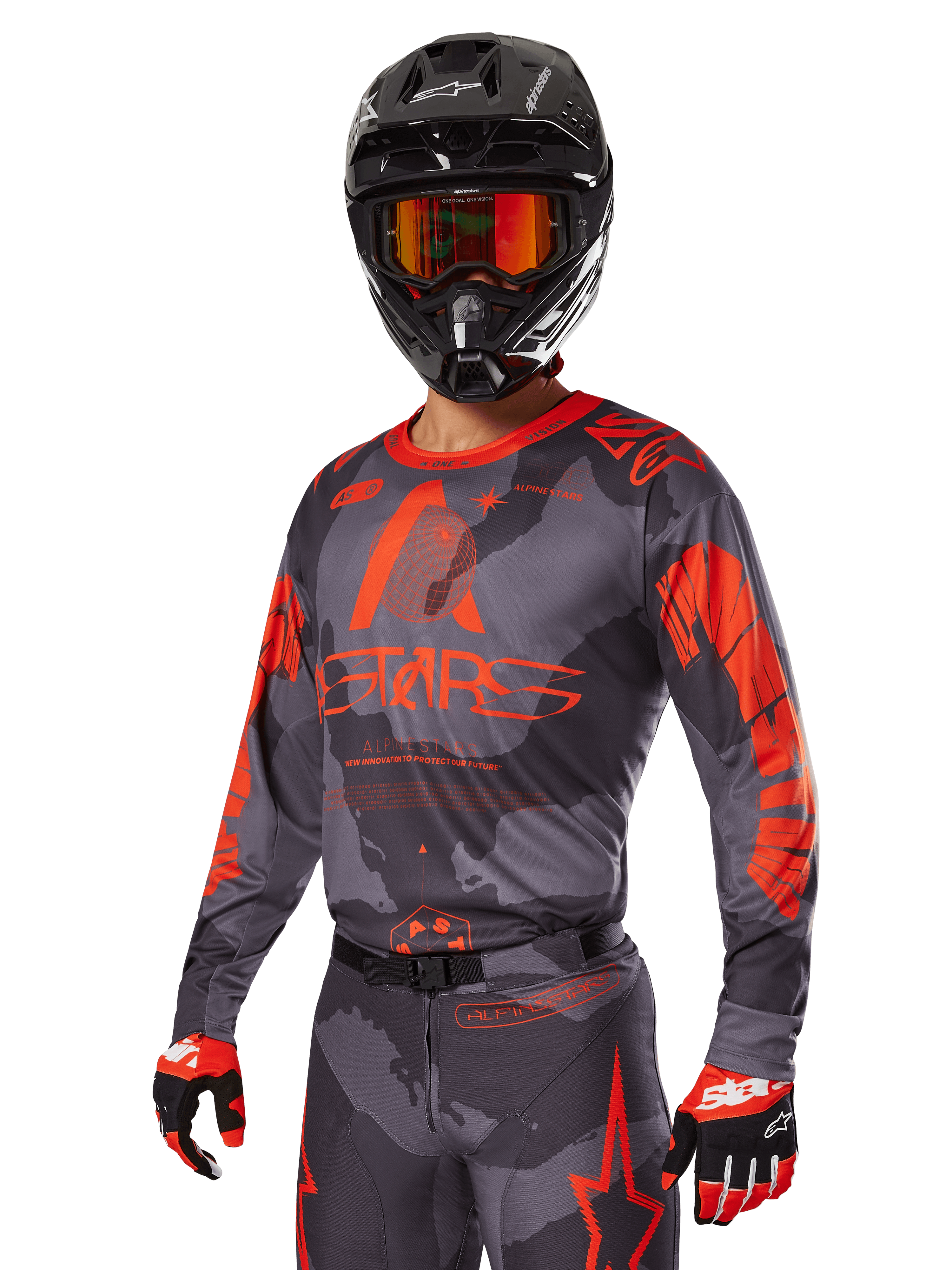 Zawodnik motocrossowy w zestawie Alpinestars 2025 Racer Hollow Red, szaro-czarny wzór kamuflażu z wyrazistym czerwonym brandingiem, komplet z koszulką, spodniami, rękawicami oraz czarnym kaskiem z czerwonymi goglami.