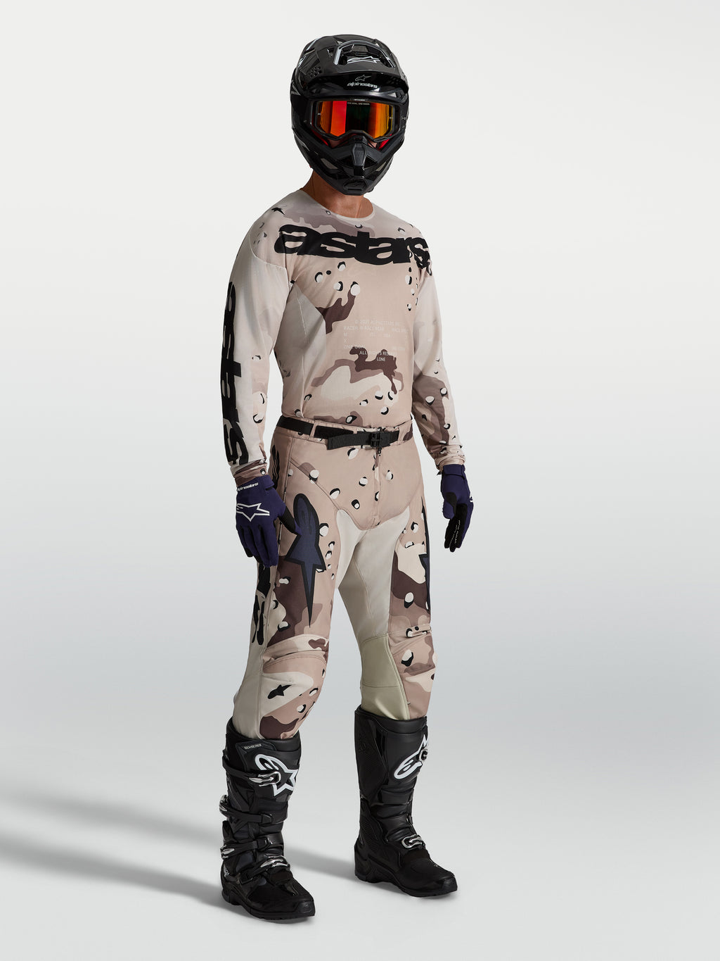 Alpinestars Koszulka Racer Lone, męska koszulka motocrossowa w kamuflażu pustynnym i czarnym, lekka i oddychająca konstrukcja, model w pełnym stroju off-road.