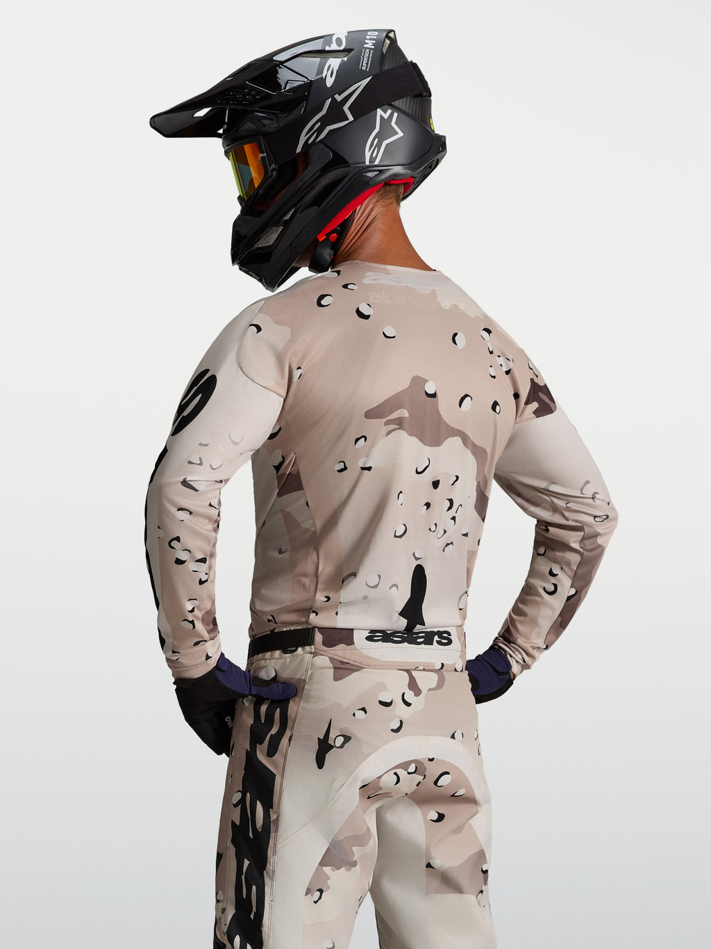 Alpinestars Racer Lone, męska koszulka motocrossowa, pustynne moro i czarna, widok od tyłu na modela, lekka i oddychająca konstrukcja z polifabryku o wyścigowym kroju.