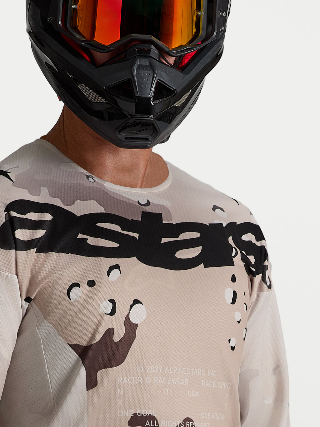 Alpinestars koszulka Racer Lone, męska koszulka motocrossowa, pustynny kamuflaż i czerń, zbliżenie na modela w kasku.