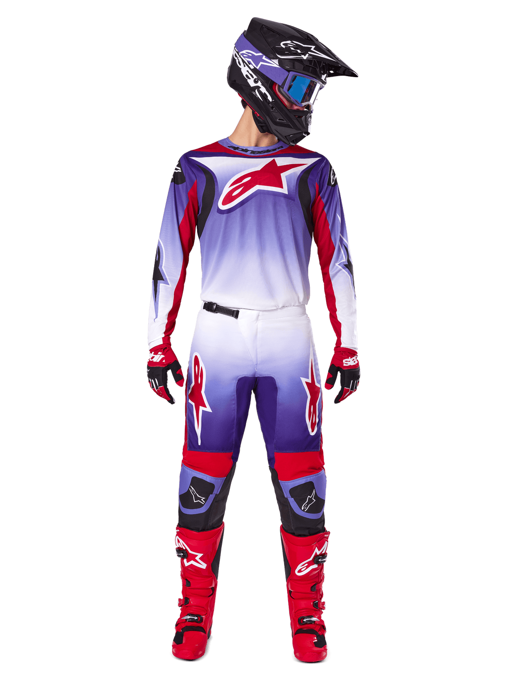 Zawodnik motocrossowy w kompletnym stroju wyścigowym Alpinestars, koszulka Fluid Wurx 2025 w kolorze fioletowo-jasnoczerwonym z białymi akcentami i dużym czerwonym logo z gwiazdą, pasujące spodnie, czerwone buty oraz czarny kask z goglami, spójny zestaw do wyścigów off-road