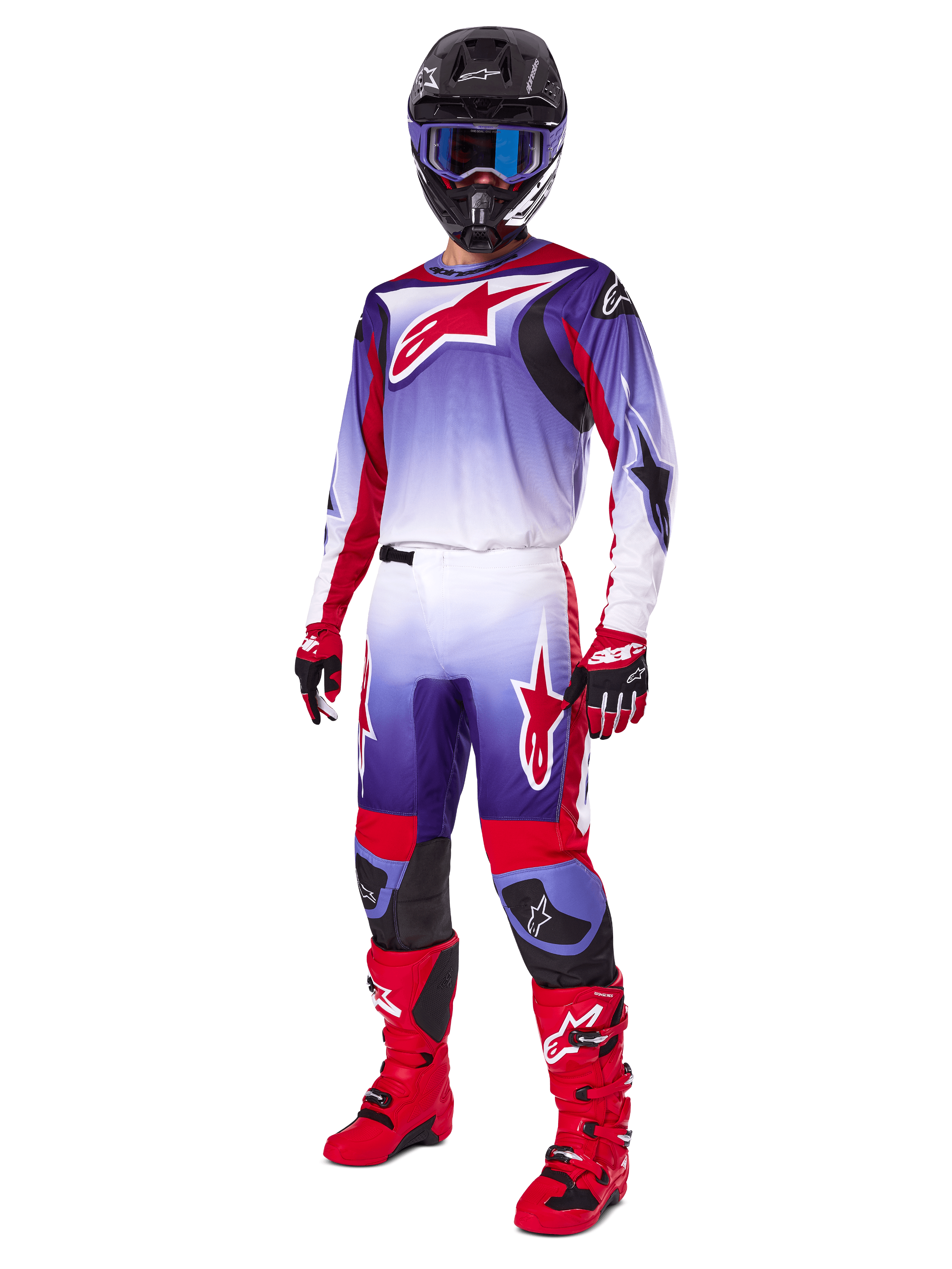Motocyklista motocrossowy w zestawie Alpinestars 2025 Fluid Wurx, fioletowo-jaskrawoczerwona koszulka z białymi akcentami, pasujące spodnie motocrossowe, jaskrawoczerwone buty, czarny kask z niebieskimi goglami i czerwono-czarne rękawice, pełny profesjonalny zestaw wyścigowy off-road