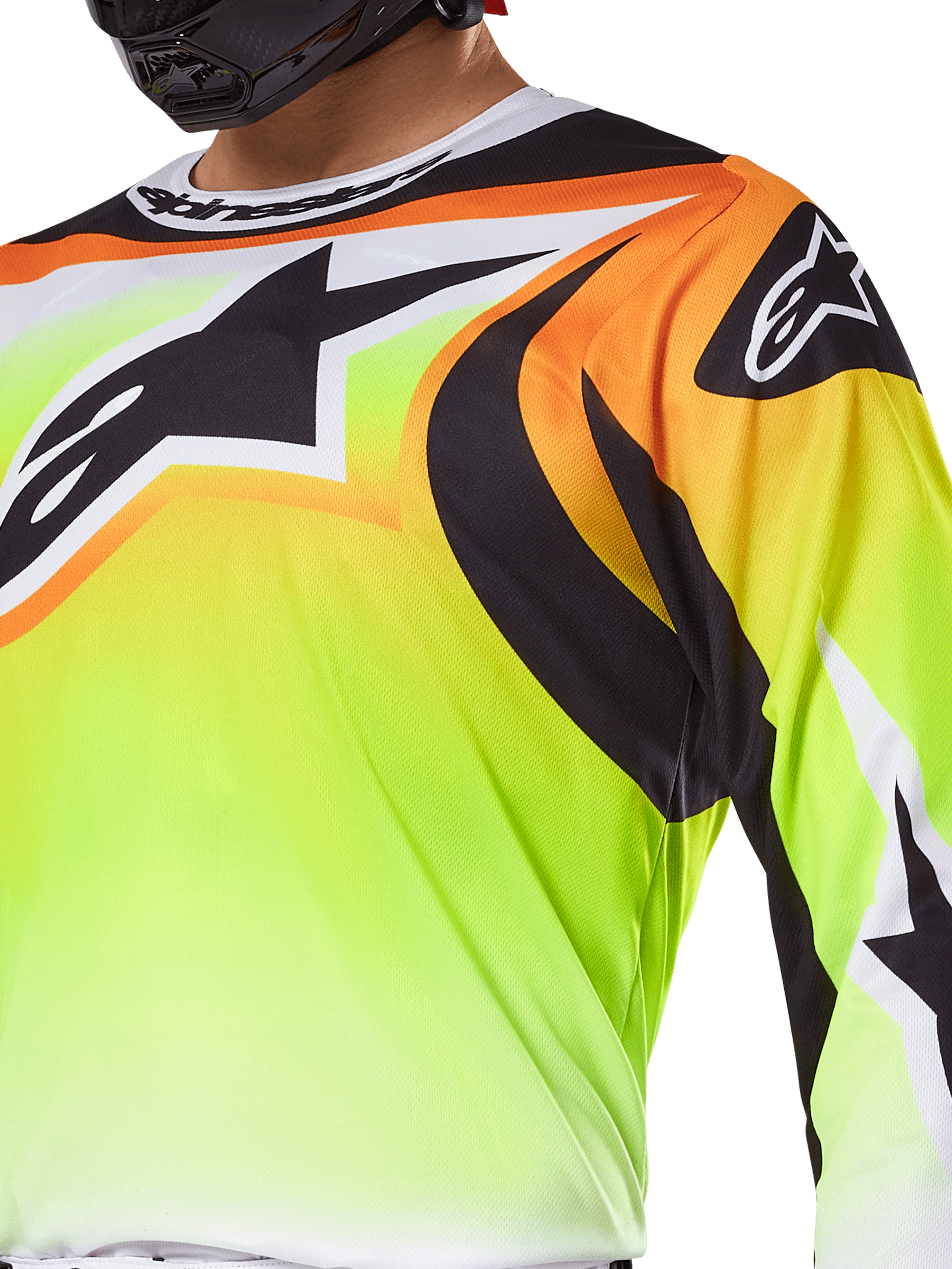Koszulka Alpinestars Fluid Wurx 2025, koszulka motocrossowa, neonowożółta z czarną i pomarańczową grafiką, duże czarne logo Alpinestars na klatce piersiowej i ramieniu, noszona przez motocyklistę w czarnym kasku