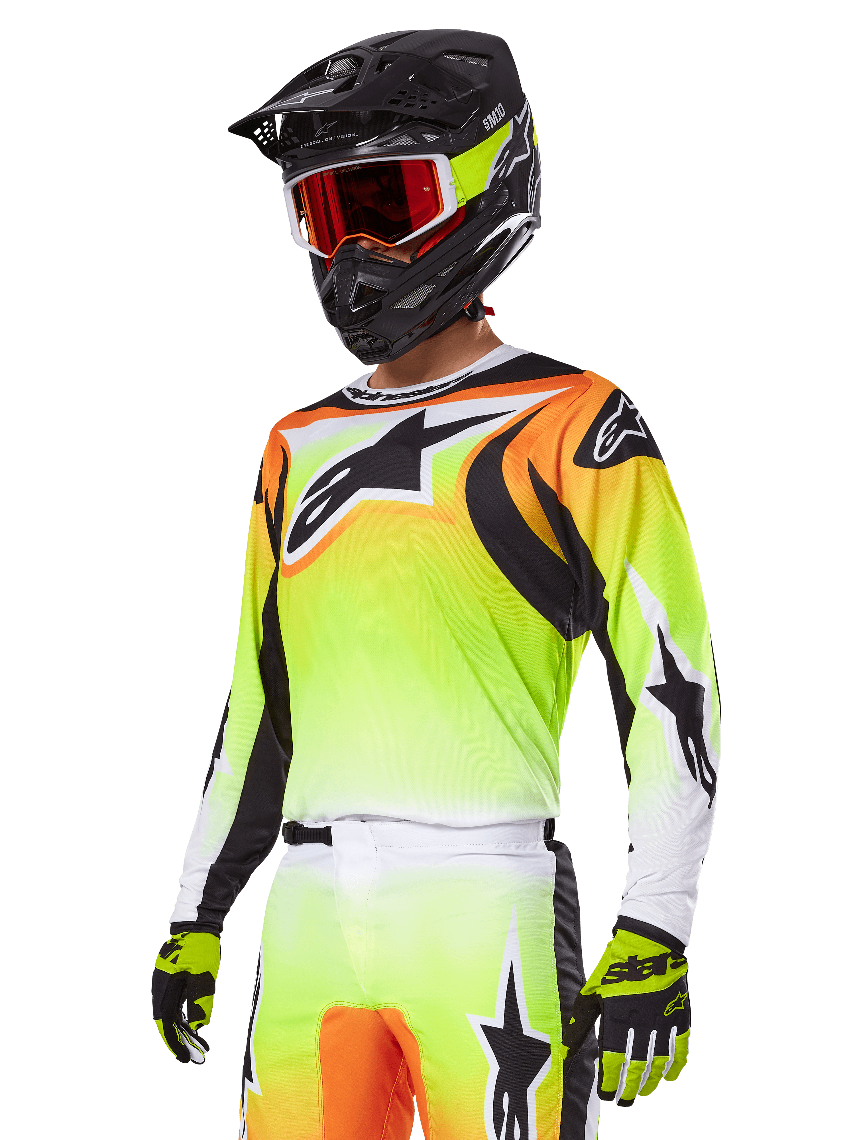 Motocyklista motocrossowy w zestawie Alpinestars 2025 Fluid Wurx, koszulka z żółto-pomarańczowym gradientem, czarnymi akcentami i dużym logo gwiazdy, pasujące spodnie motocrossowe, czarny kask z czerwonymi goglami i żółte rękawice, skoordynowany wyczynowy strój do wyścigów terenowych