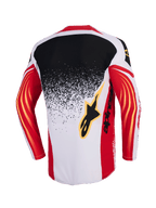 Alpinestars Techstar Nomur Jersey 2026, koszulka motocrossowa, jasnoszara, czerwona i czarna, widok z tyłu z czarno-jasnoszarym gradientowym wzorem typu splatter, czerwone rękawy z żółtymi zakrzywionymi akcentami, czarne logo Alpinestars na plecach