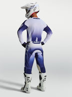 Alpinestars Racer Air Amber, zestaw odzieży motocrossowej, granatowa i biała siatkowa koszulka oraz spodnie, widok z tyłu na modelu w stroju wyścigowym.