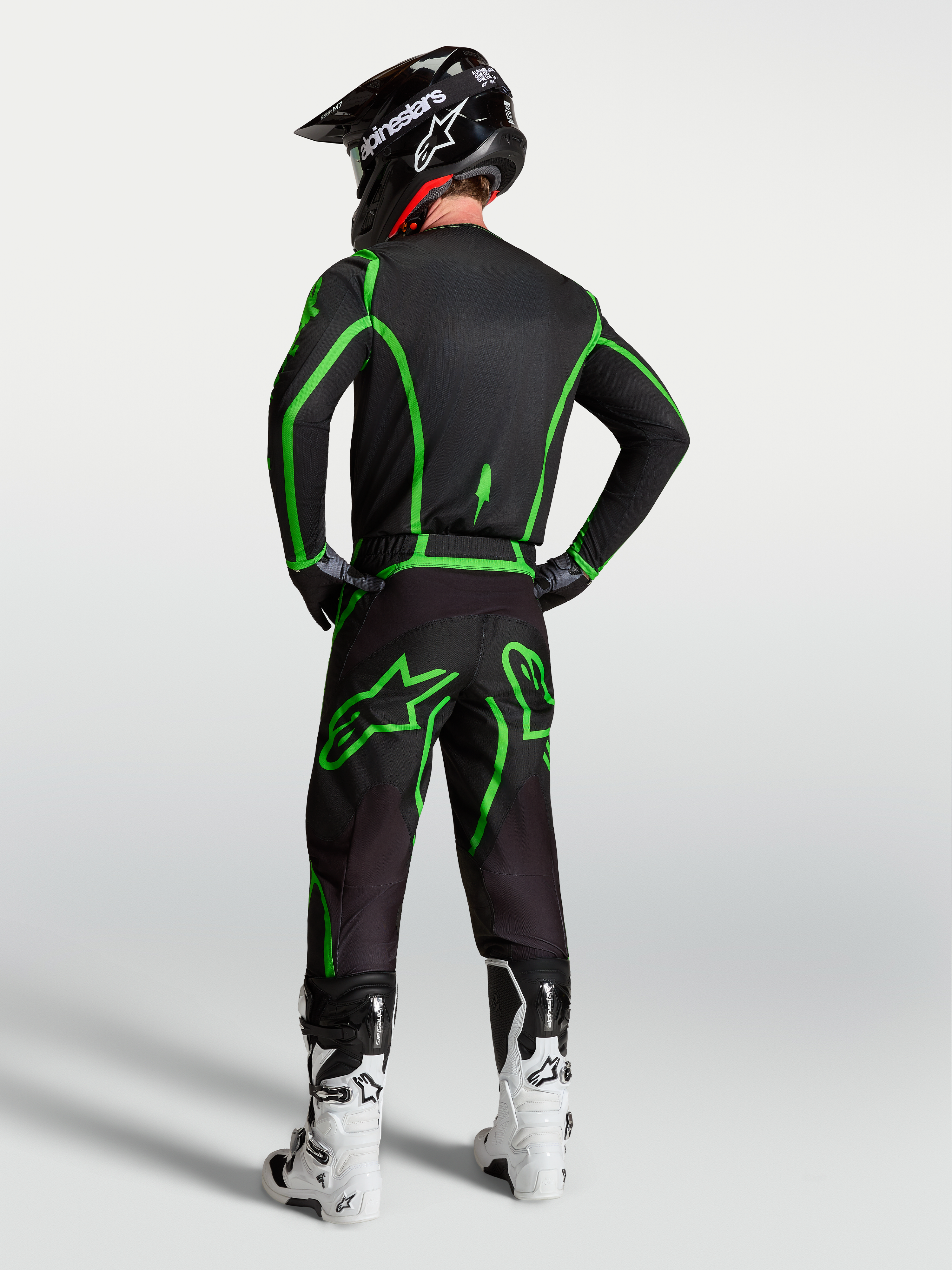 Spodnie Alpinestars Fluid Apex V2, męskie spodnie motocrossowe, czarne i zielone fluo, ergonomiczny krój zaprezentowany w pełnym zestawie odzieży, widok od tyłu.
