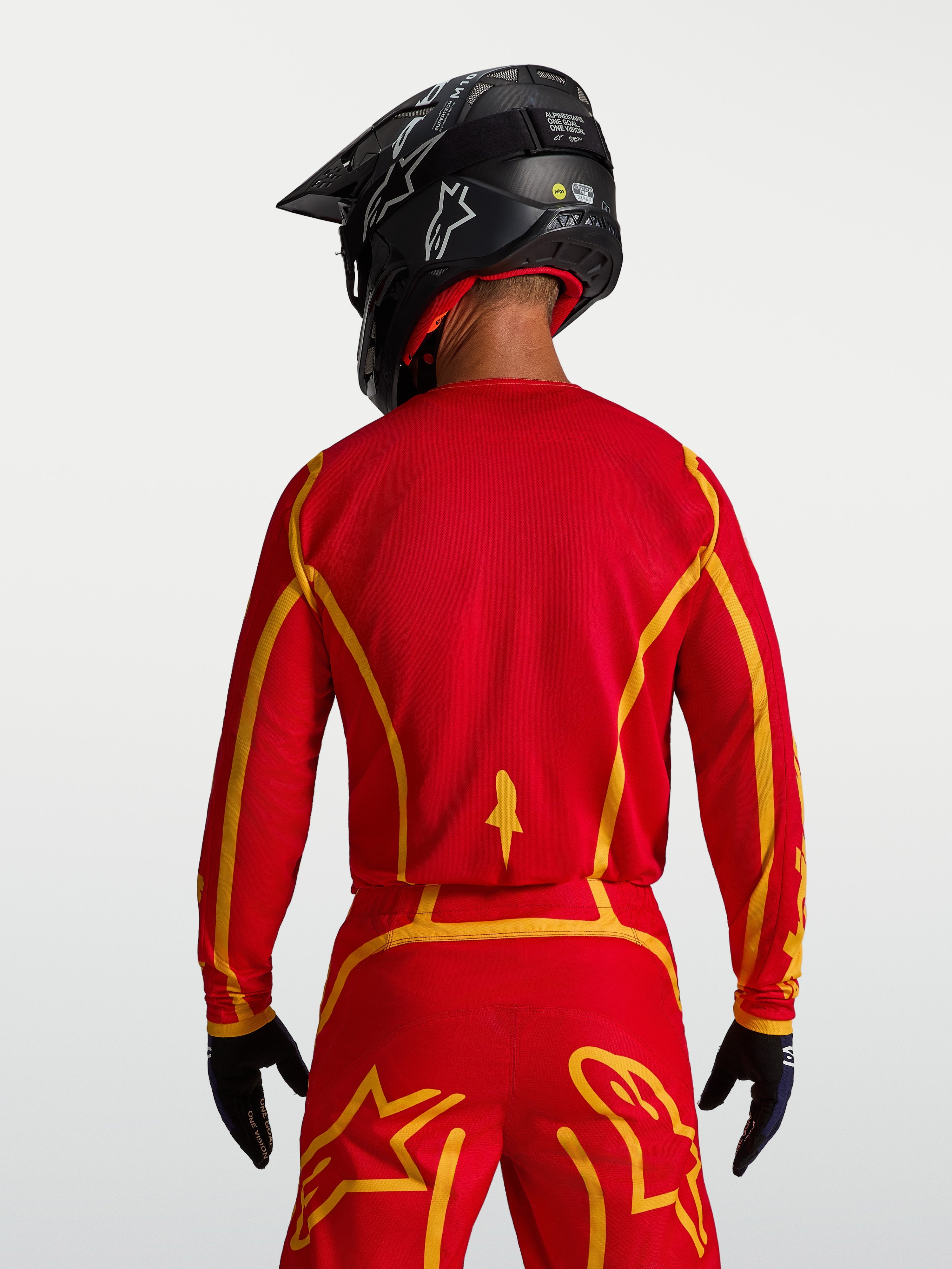 Alpinestars Fluid Apex V2, męska koszulka motocrossowa, czerwona i złota, tył, ergonomiczny krój, oddychający materiał.