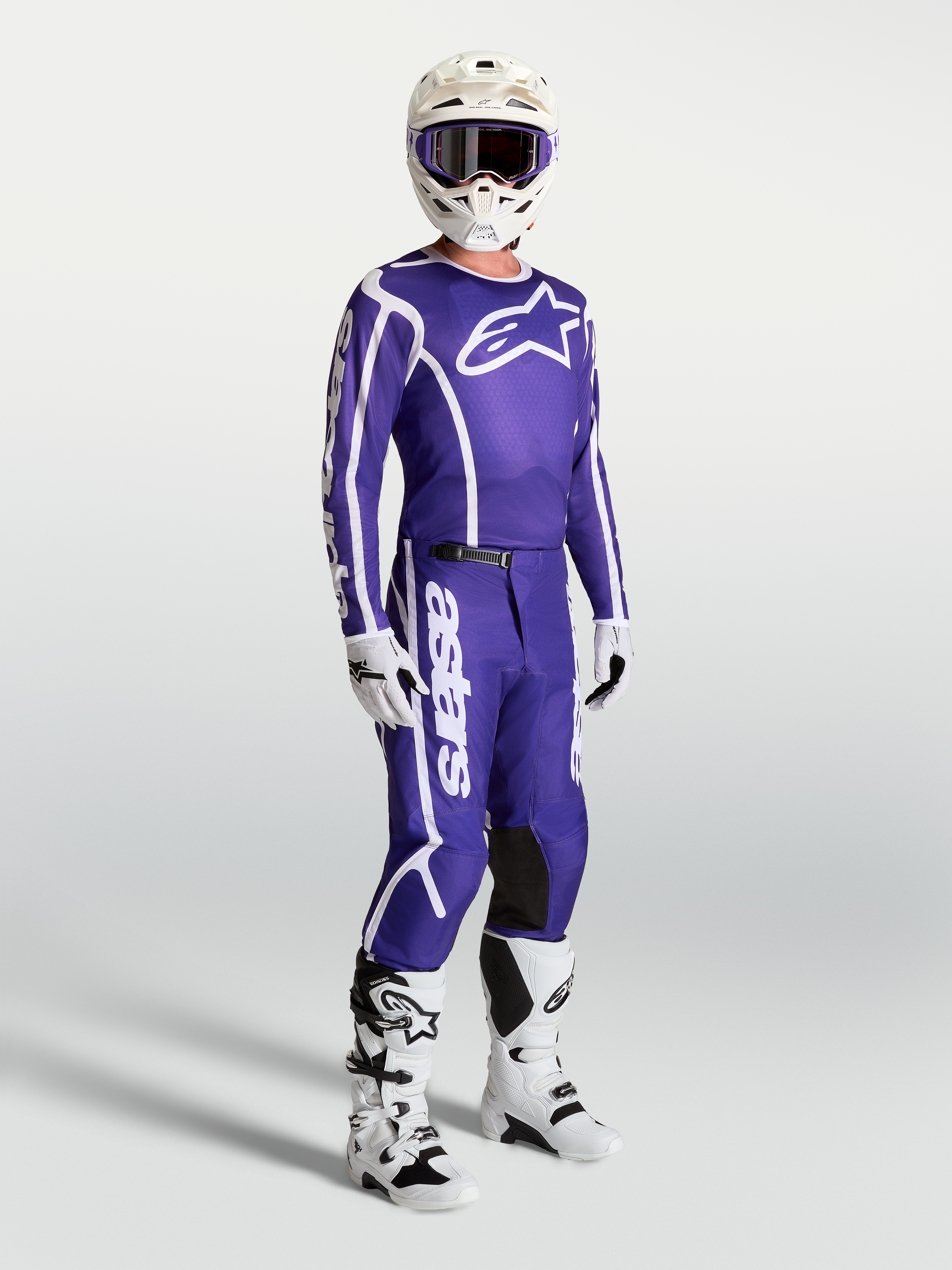 Alpinestars Koszulka Fluid Apex V2 i spodnie, niebieski i biały zestaw motocrossowy na modelu z kaskiem i butami