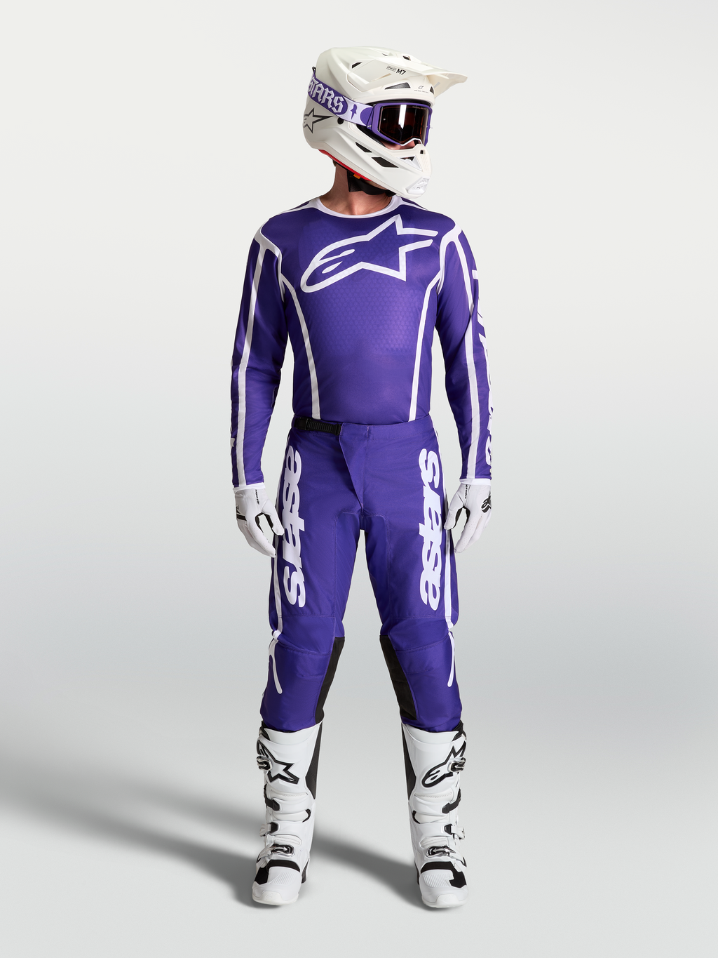 Alpinestars Koszulka Fluid Apex V2 i Fluid Apex V2 Gear Set, niebiesko-biała odzież motocrossowa z kaskiem i butami.