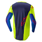 Alpinestars 2024 Racer Hoen Jersey, koszulka motocrossowa, żółty fluo i granatowy, widok z tyłu przedstawiający ciemnoniebieski panel środkowy z czerwonym logo, jaskrawożółte sekcje boczne, długie rękawy i oddychająca tkanina siatkowa zaprojektowana do jazdy w terenie.
