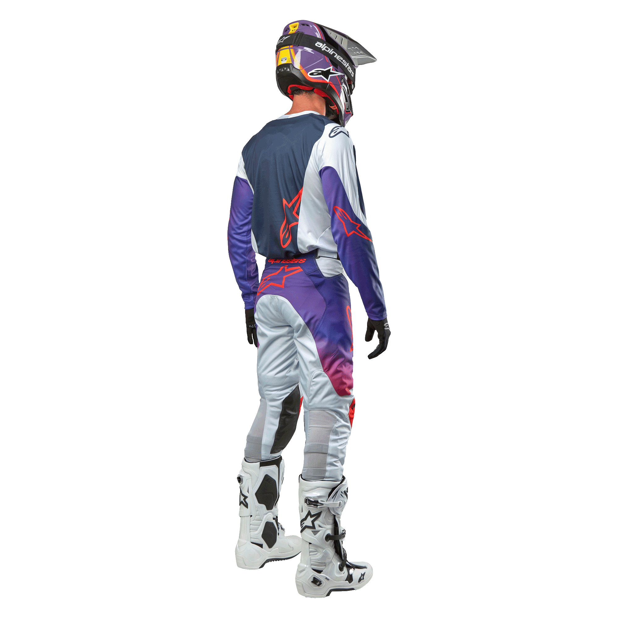 Zawodnik motocrossowy widziany od tyłu, ubrany w koszulkę Alpinestars 2024 Racer Hoen Jersey w kolorze Light Gray Hot Orange Black, granatowy panel tylny z pomarańczowym logo gwiazdy, fioletowe rękawy, pasujące spodnie wyścigowe i białe buty.
