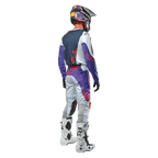 Alpinestars 2024 Racer Hoen Pants, spodnie motocrossowe, jasnoszare z fioletowymi i pomarańczowymi akcentami, widok od tyłu, logo gwiazdy na siedzeniu, sportowy krój, białe buty motocyklowe i kask