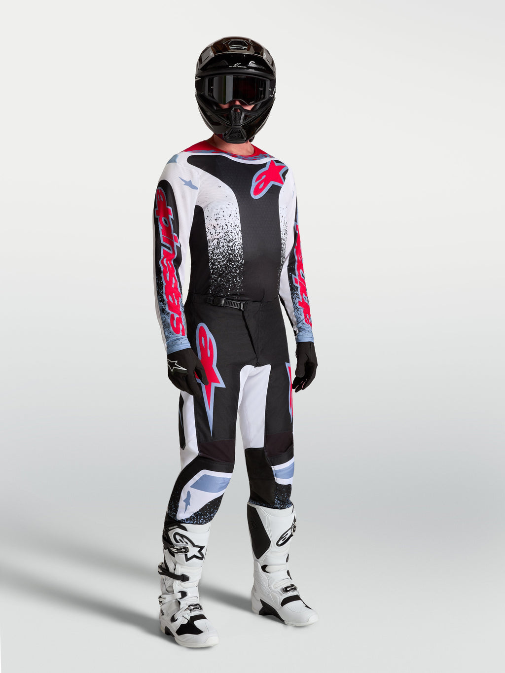 Alpinestars 2027 Fluid Drag Gear Set, męski wyścigowy strój motocrossowy, czarno-biały z czerwoną grafiką i białymi butami.