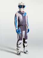 Alpinestars 2027 Fluid Drag Jersey, gray and blue motocross gear set with matching pants, helmet, and white boots.