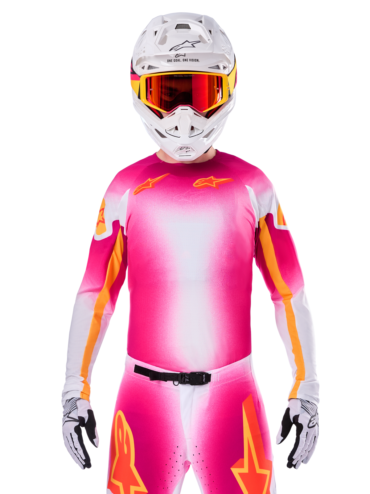 Zawodnik motocrossowy w koszulce Alpinestars Limited Edition Supertech AFD MIG, różowo-biały gradient Pink Fluo White z pomarańczowymi logotypami gwiazdy, pasujące spodnie, biały kask i gogle z czerwonymi szkłami, profesjonalna odzież wyścigowa off-road