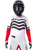 Motocross rider wearing complete racing gear, Limited Edition Techstar Deep Jersey in white and black with red sleeves, featuring wavy graphics and bold Alpinestars branding, white motocross pants, black helmet and goggles, coordinated outfit for off-road racing