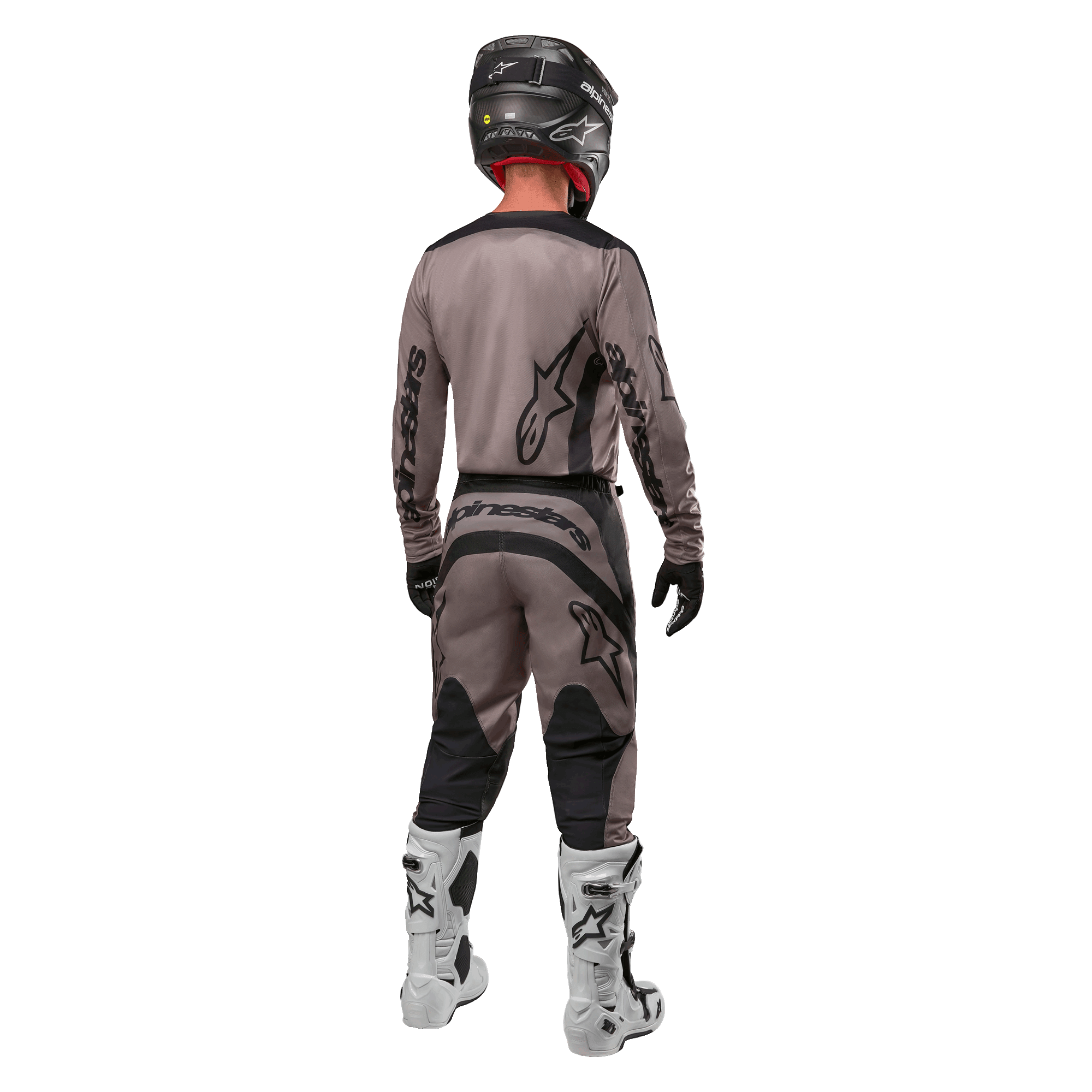 Alpinestars 2024 Fluid Lurv Jersey, koszulka motocrossowa, Mud Black, widok z tyłu zawodnika motocrossowego w dopasowanym stroju wyścigowym, czarny kask i białe buty, wyraźne czarne logotypy Alpinestars, sportowy krój zapewniający wydajność w terenie