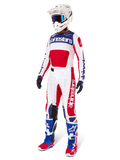 Alpinestars Limited Edition Techstar Fortitude Gear Set, strój motocrossowy, czerwony, biały i niebieski, biała koszulka z wyrazistymi grafikami, pasujące spodnie wyścigowe, biały kask z goglami, dopasowane niebieskie i czerwone buty, profesjonalny sprzęt wyścigowy do jazdy w terenie