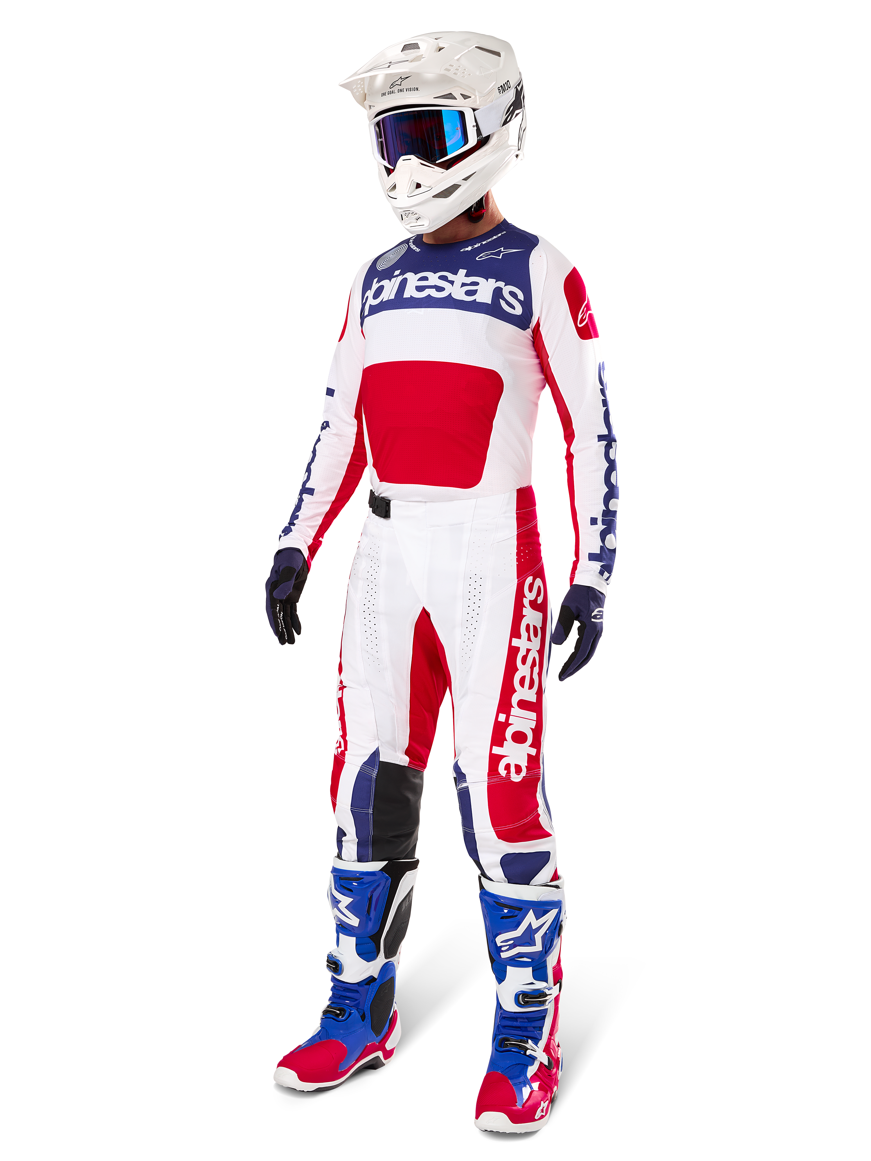 Alpinestars Limited Edition Techstar Fortitude Gear Set, strój motocrossowy, czerwony, biały i niebieski, biała koszulka z wyrazistymi grafikami, pasujące spodnie wyścigowe, biały kask z goglami, dopasowane niebieskie i czerwone buty, profesjonalny sprzęt wyścigowy do jazdy w terenie