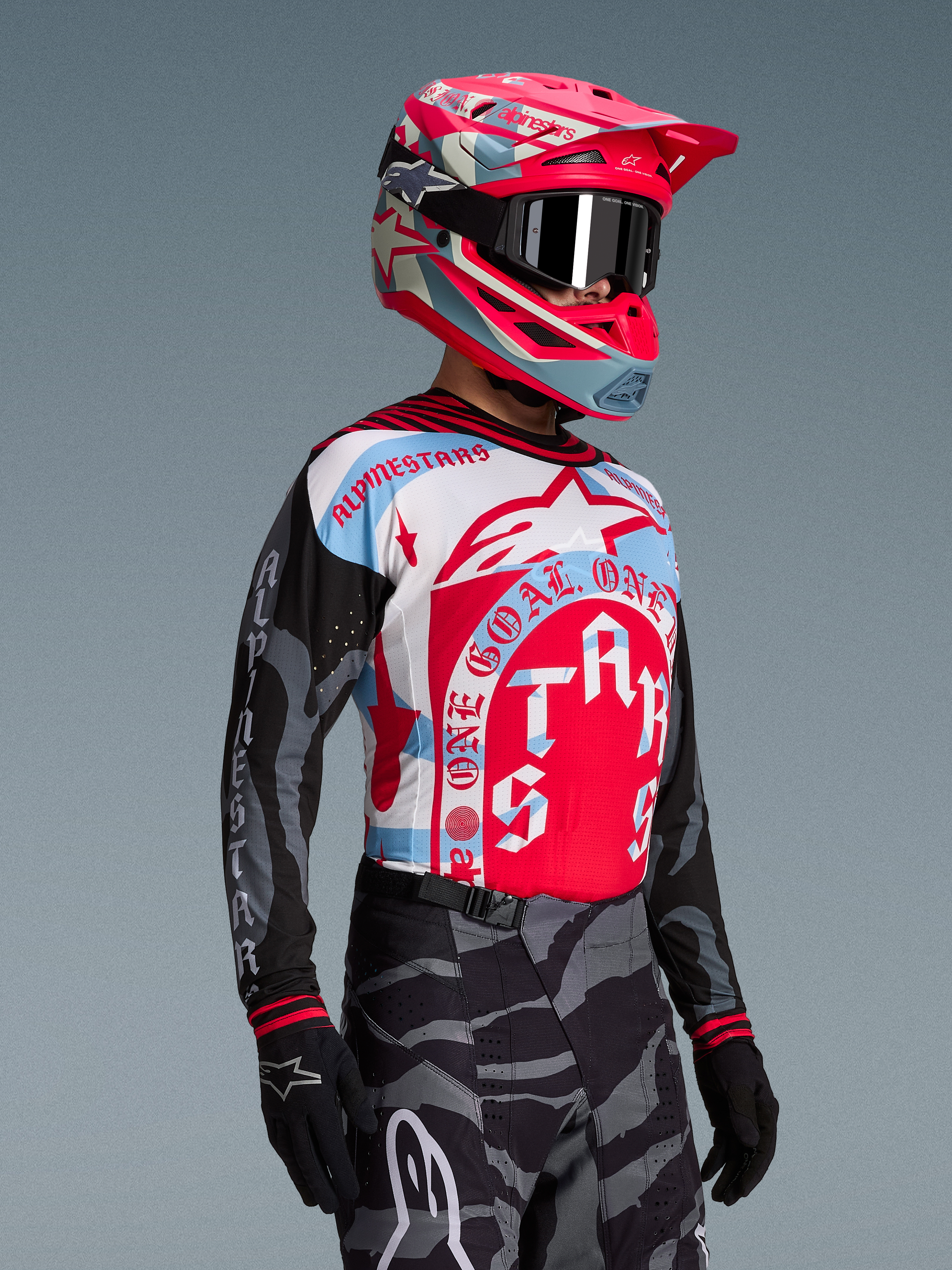 Koszulka Techstar Beast Coast Edycja Limitowana, biało-czerwono-niebieski wzór, różowy kask MX i czarne gogle.