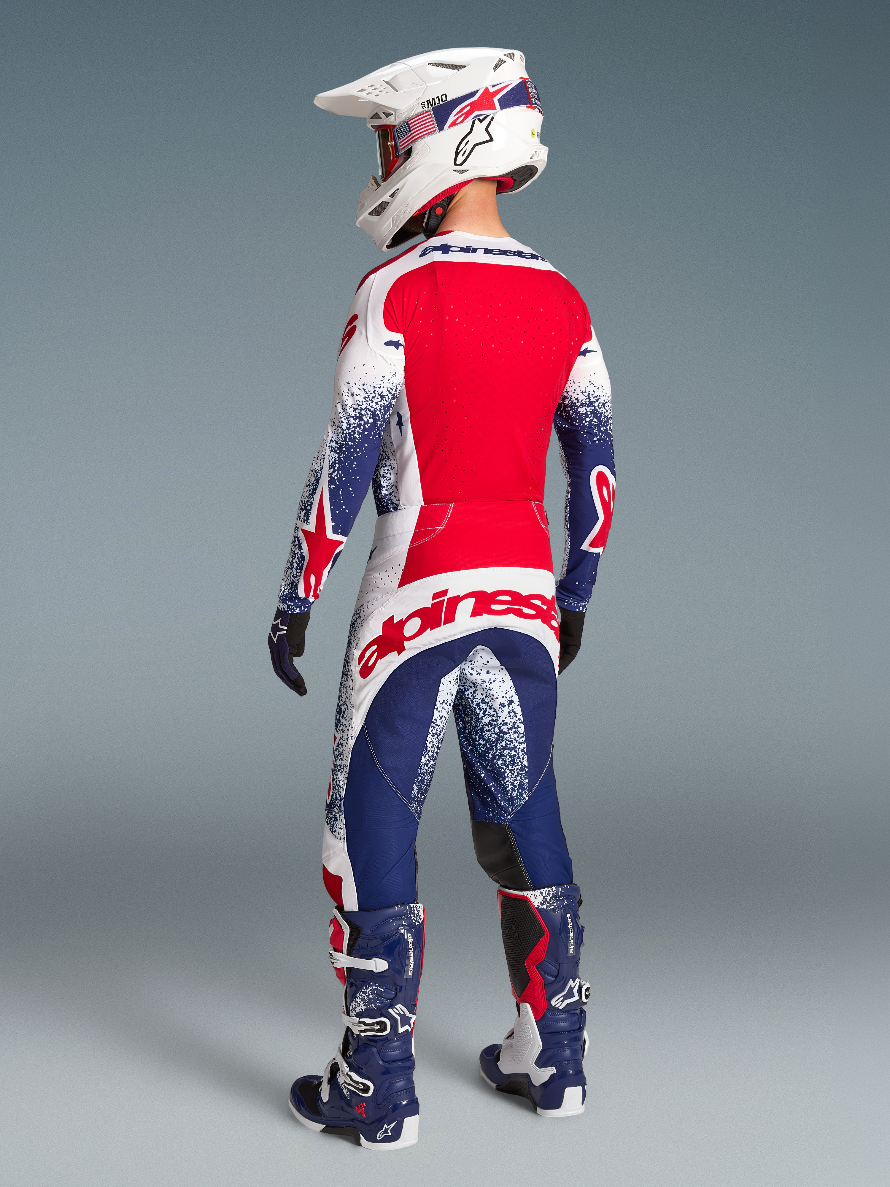 Alpinestars Techstar Unity, koszulka i spodnie motocrossowe, edycja limitowana, czerwono-biało-niebieskie, widok z tyłu.
