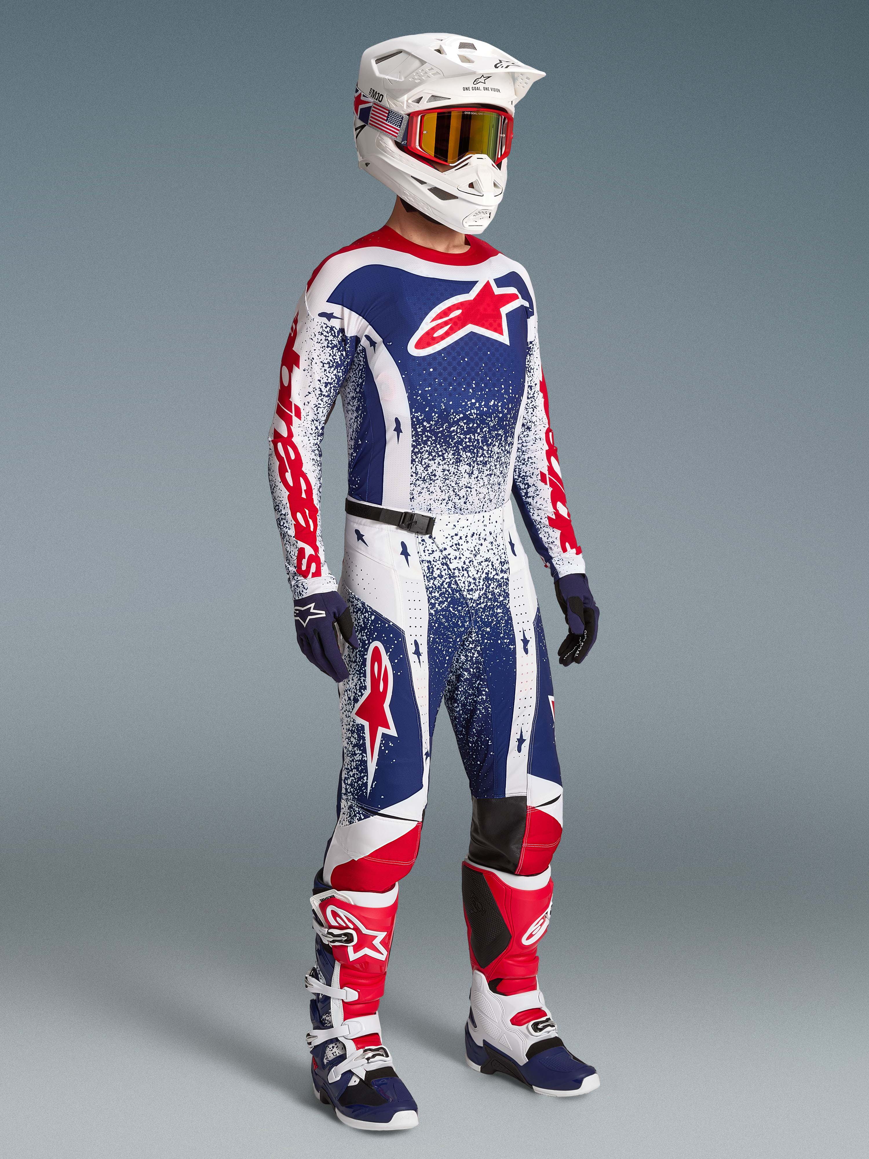 Zestaw Alpinestars Techstar Unity Edycja Limitowana, czerwono-biało-niebieska koszulka i spodnie motocrossowe na modelu.