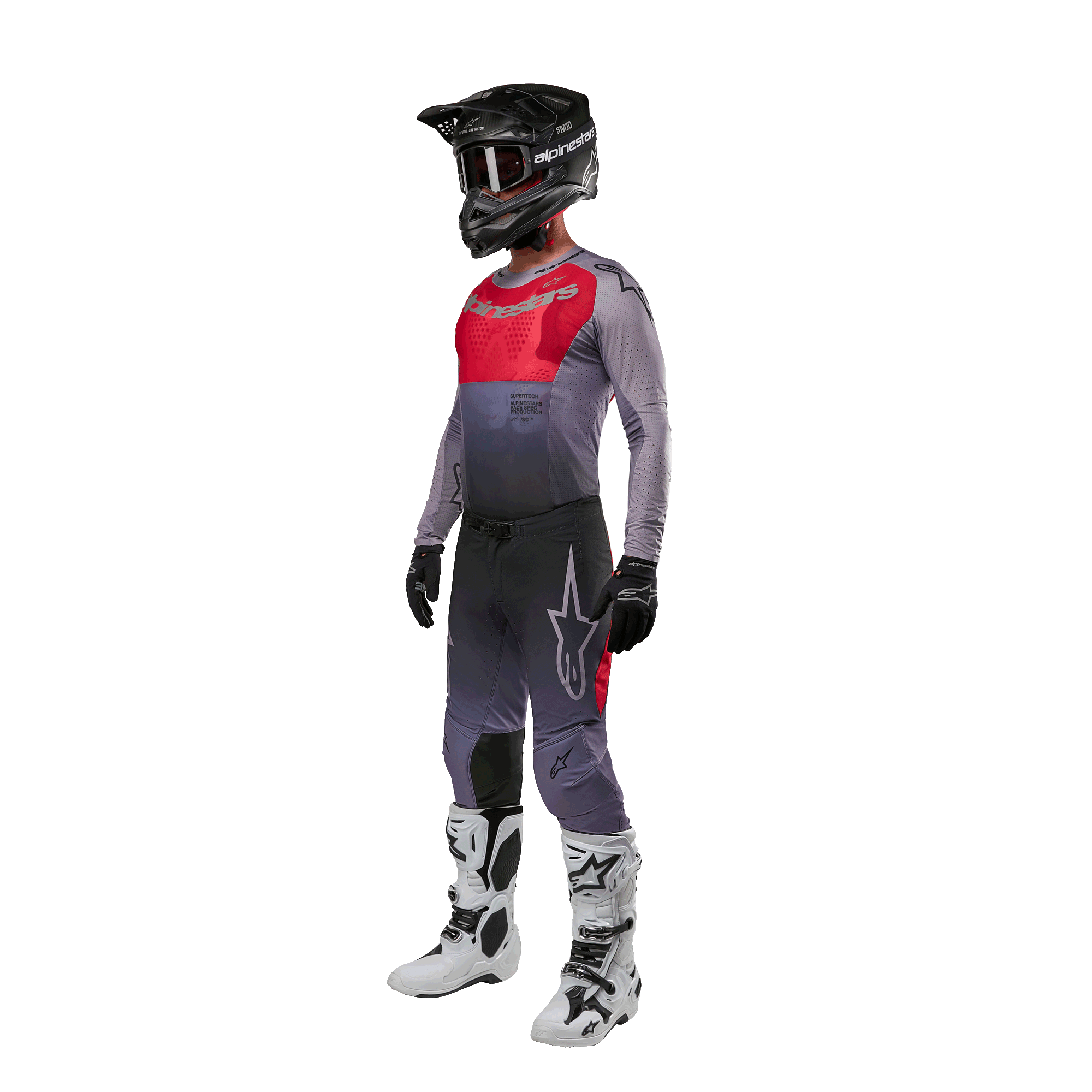 Zawodnik motocrossowy w pełnym stroju wyścigowym, koszulka Alpinestars 2024 Supertech Dade w kolorze Iron Red Berry i szarym, pasujące szare spodnie z czerwonymi akcentami, czarny kask z goglami, biało-czarne buty, czarne rękawice, spójny zestaw do wyścigów off-road
