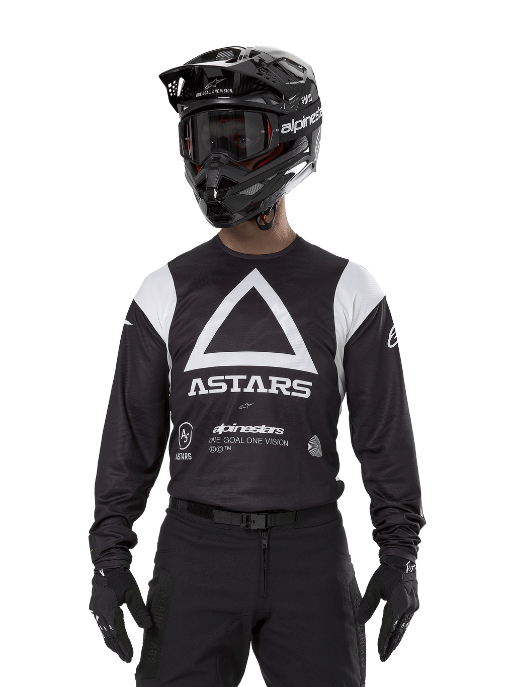 Alpinestars Techdura Jersey, czarna koszulka enduro, duża biała grafika z trójkątem i logo ASTARS na klatce piersiowej, białe panele na ramionach, motocyklista w czarnym kasku motocrossowym, goglach i pasującym czarnym stroju terenowym