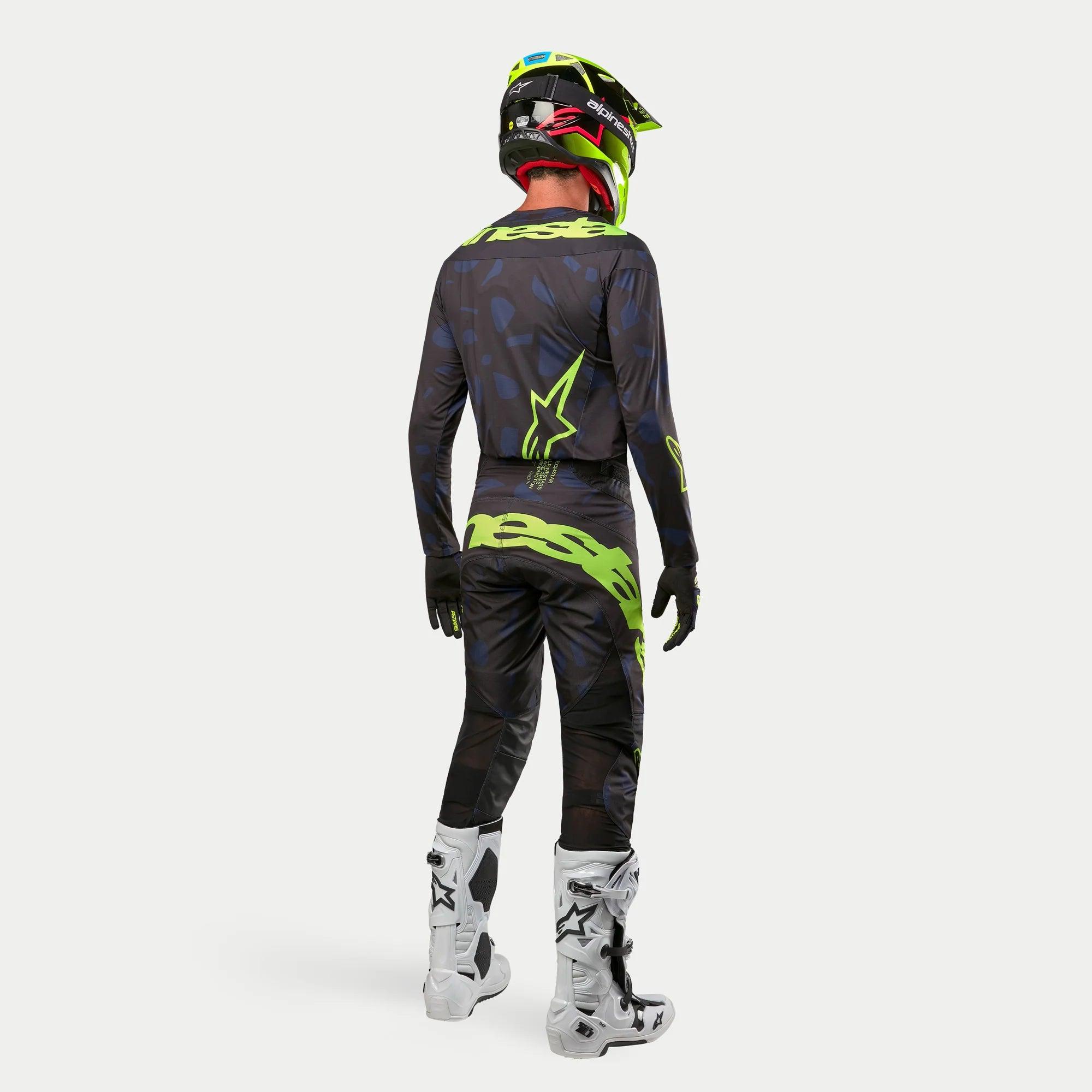 Alpinestars 2024 Techstar Rantera Jersey, koszulka motocrossowa, czarna, granatowa i żółta neonowa, noszona z pasującymi spodniami, biało-czarnymi butami i żółtym neonowym kaskiem, widok z tyłu w pełnym stroju do wyścigów terenowych