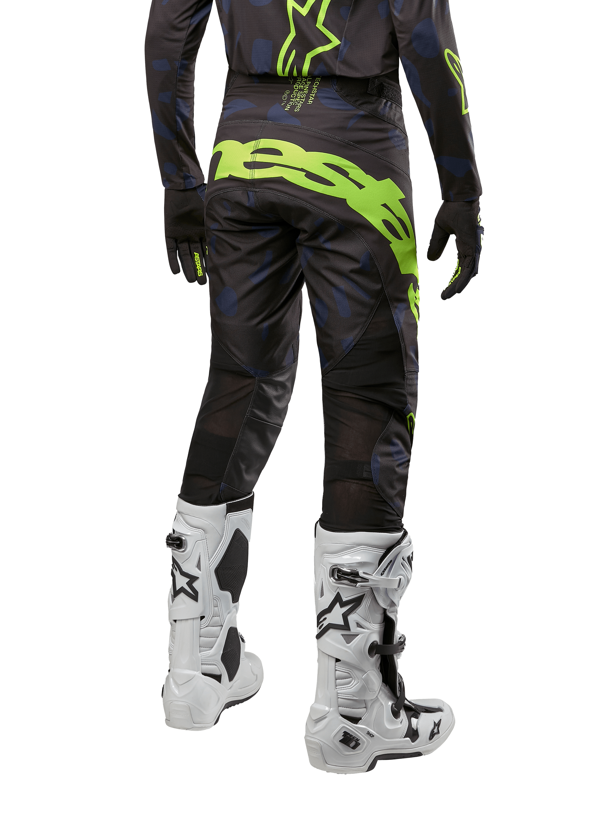 Alpinestars Techstar Rantera Pants 2024, spodnie motocrossowe, czarne, granatowe i neonowo-żółte, widok z tyłu, wyraziste neonowe logo i siatkowe panele wentylacyjne, noszone z pasującą bluzą i białymi butami, wytrzymały sprzęt do motocrossu i wyścigów off-road