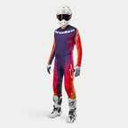 Strój motocrossowy Alpinestars Techstar Pneuma, kompletny zestaw wyścigowy, biały kask, koszulka i spodnie z fioletowym, pomarańczowym i czerwonym gradientem, biało-czarne rękawice, białe buty z czarnymi detalami, logo Alpinestars