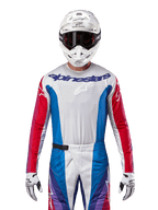 Alpinestars 2024 Techstar Pneuma Jersey, koszulka motocrossowa, niebieska, czerwona (Mars Red) i biała, widok z przodu na zawodniku w białym kasku i rękawicach, laserowo wycinane perforacje na klatce piersiowej i wyraźne logo, sportowa odzież wyścigowa do jazdy terenowej