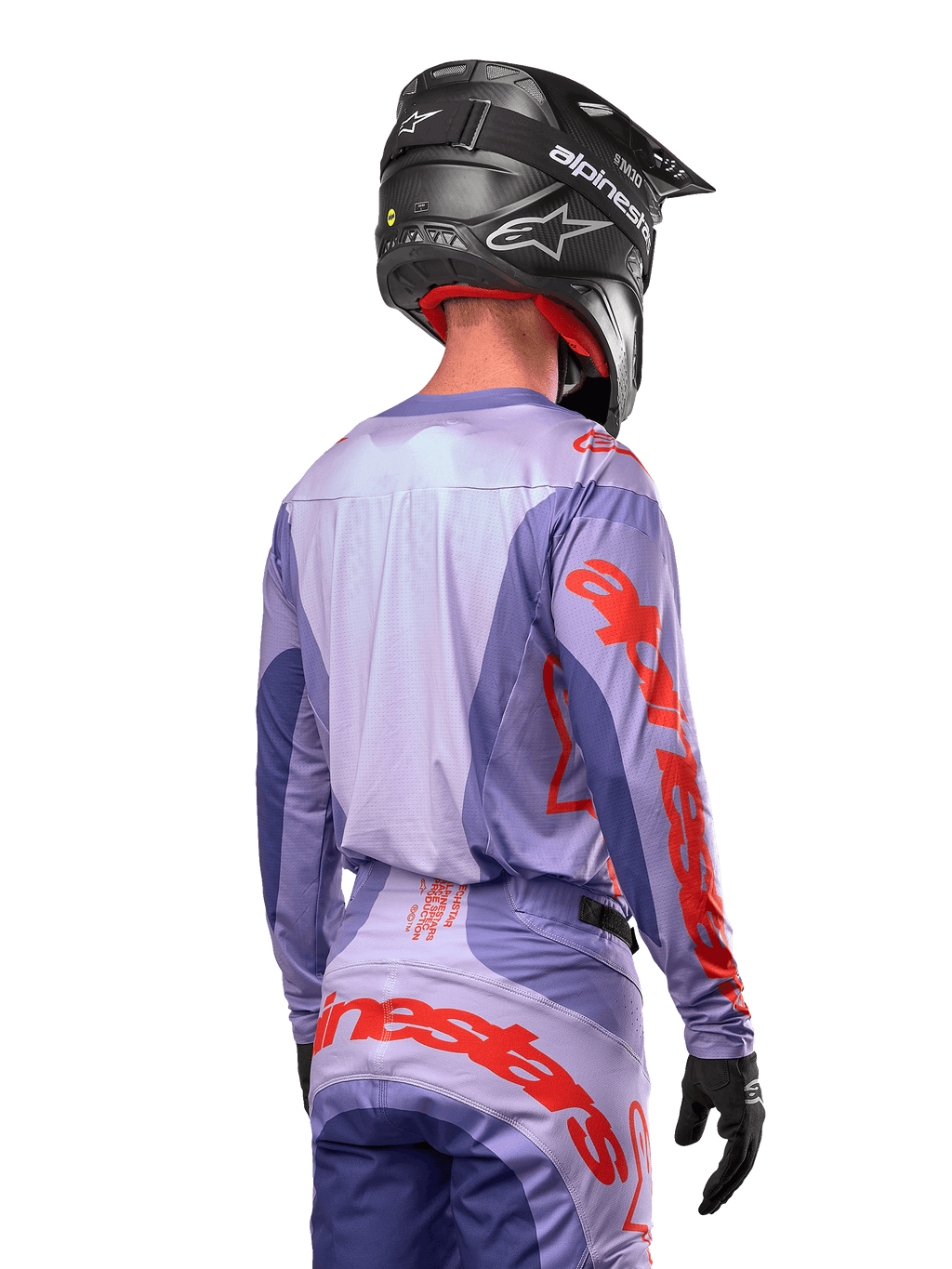 Alpinestars 2024 Techstar Ocuri Jersey, koszulka motocrossowa, fioletowa i jaskrawopomarańczowa, widok z tyłu na motocyklistę w pasującym komplecie i czarnym kasku, duże pomarańczowe napisy Alpinestars na rękawach i w dolnej części pleców
