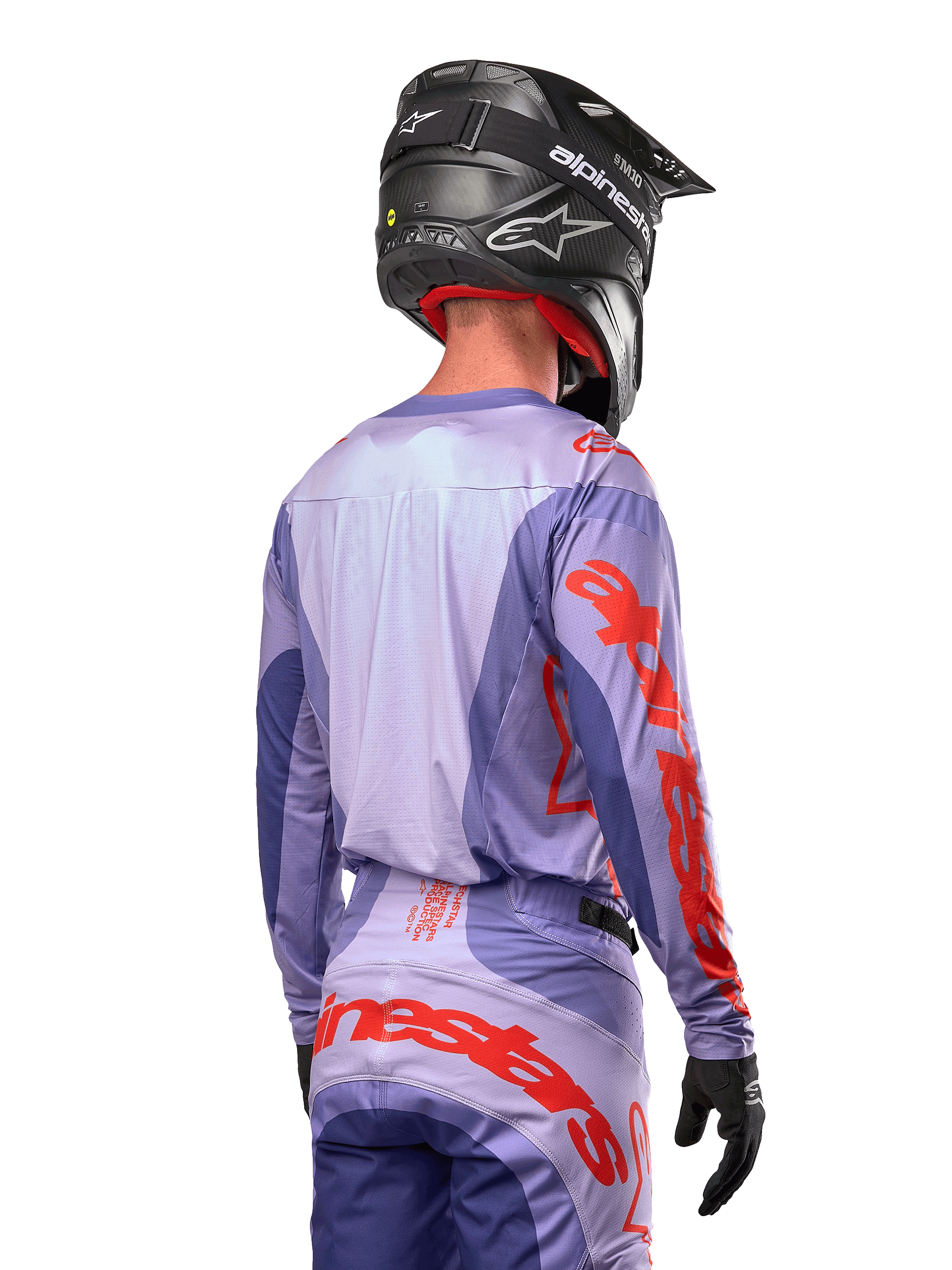 Alpinestars 2024 Techstar Ocuri Jersey, koszulka motocrossowa, fioletowa i jaskrawopomarańczowa, widok z tyłu na motocyklistę w pasującym komplecie i czarnym kasku, duże pomarańczowe napisy Alpinestars na rękawach i w dolnej części pleców