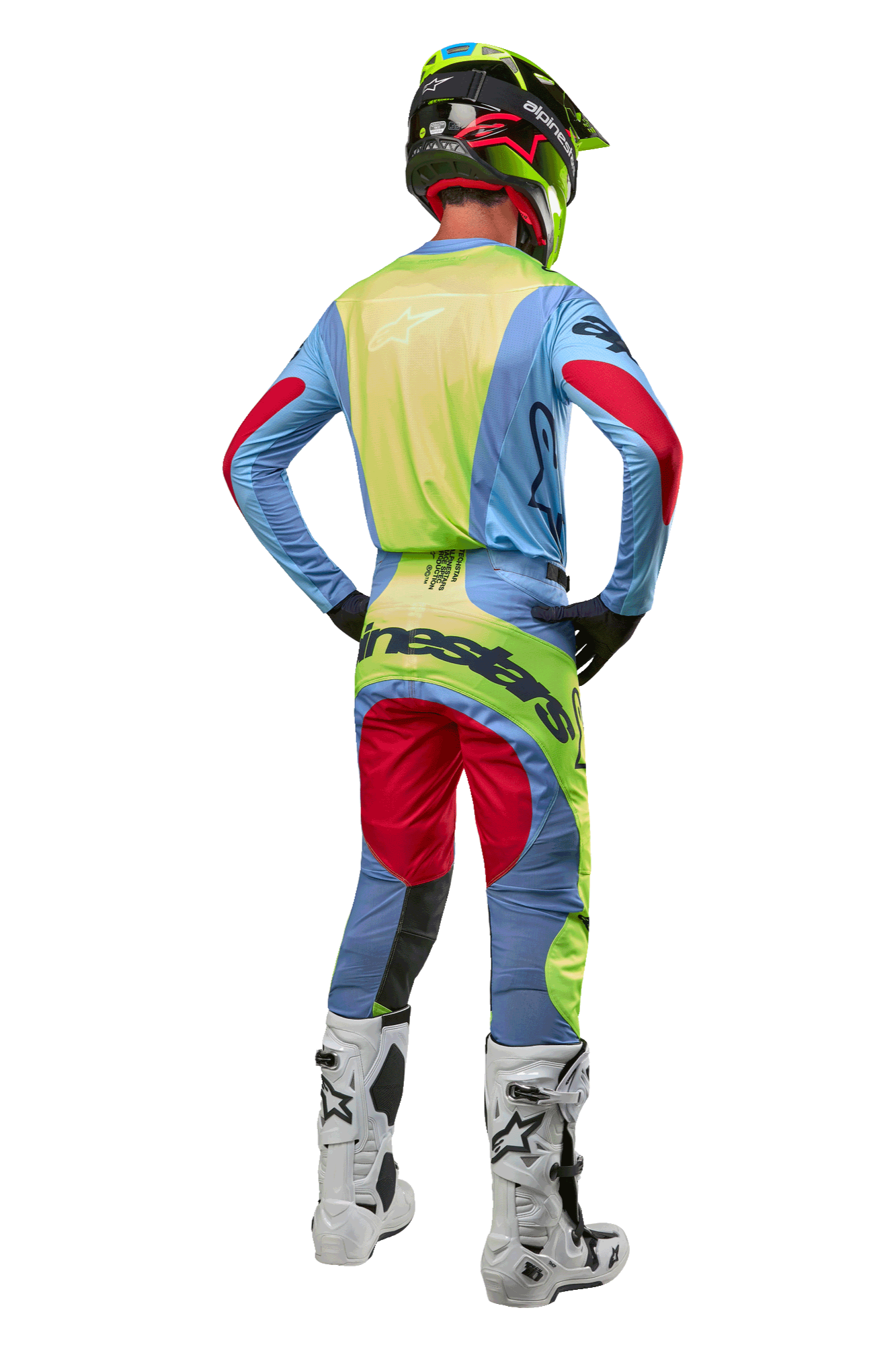 Zawodnik motocrossowy widziany od tyłu w koszulce Alpinestars 2024 Techstar Ocuri, jasnoniebieska z neonowożółtymi i czerwonymi akcentami, pasujące spodnie wyścigowe, białe buty i neonowy kask, kompletny strój off-road do profesjonalnej rywalizacji
