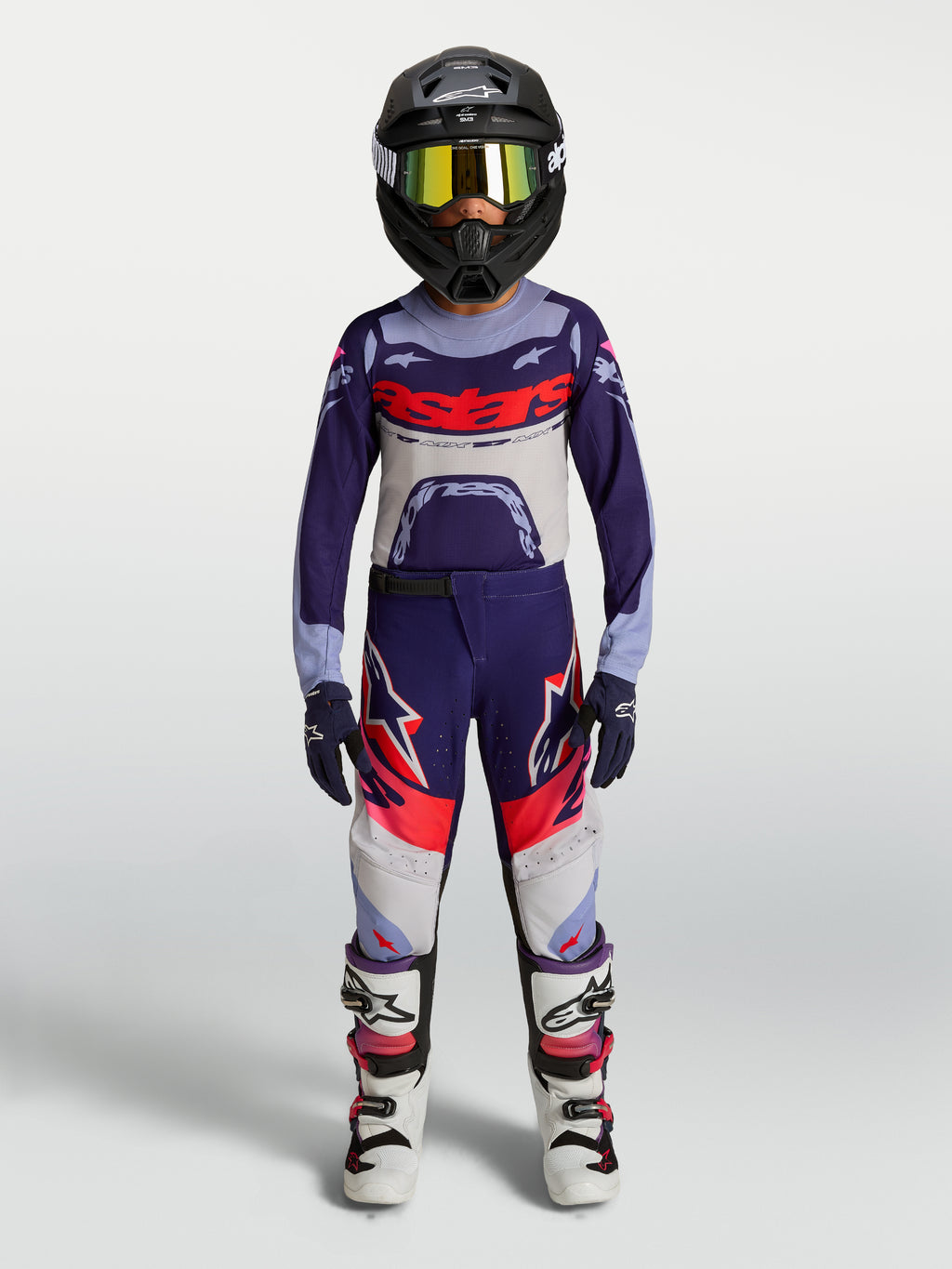 Alpinestars 2027 Youth Supertech Dyna, zestaw i koszulka MX, fioletowo-biały strój młodzieżowy z kaskiem i butami.