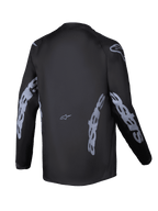 Alpinestars Youth Racer Graphite Jersey 2025, widok z tyłu, czarno-szara, koszulka motocrossowa z długim rękawem, szare logo Alpinestars na rękawach i bokach, materiał odprowadzający wilgoć, przedłużony tył do jazdy terenowej