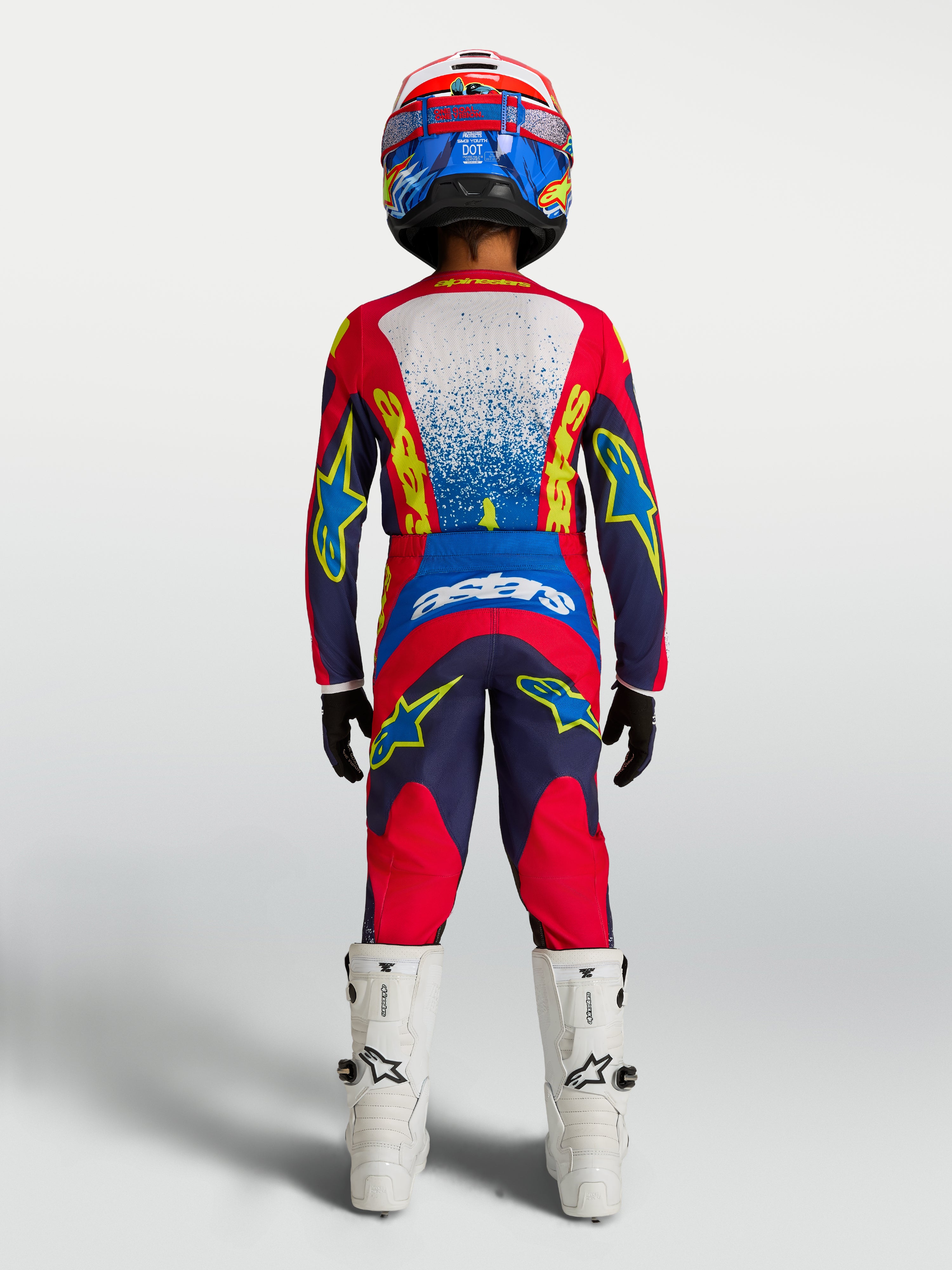 Alpinestars Młodzieżowy zestaw i koszulka Fluid Drag 2027, granatowy i czerwony strój motocrossowy, widok z tyłu na zawodniku.