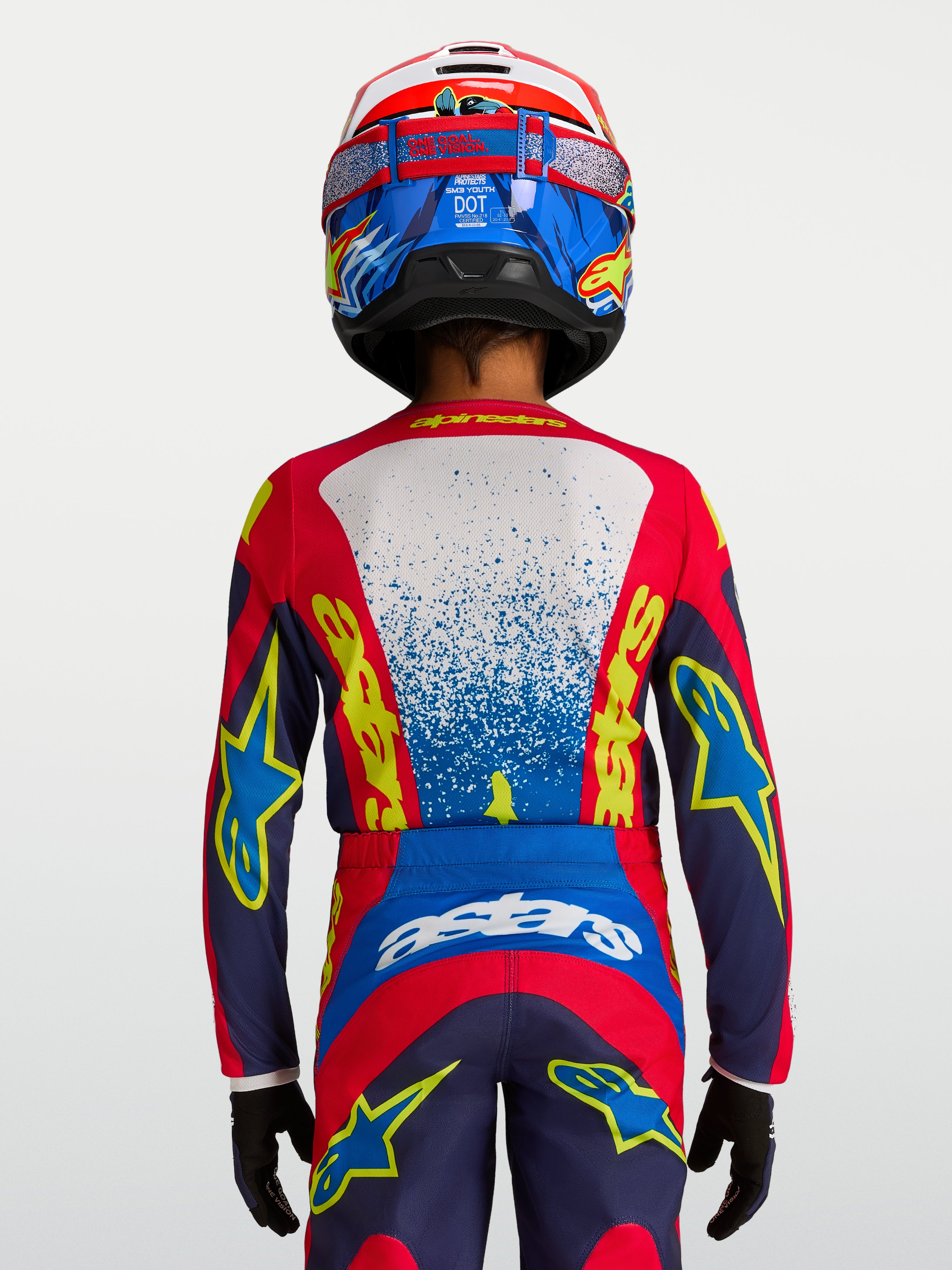 Alpinestars koszulka Fluid Drag młodzieżowe, koszulka motocrossowa, niebieska i czerwona, widok z tyłu na ergonomiczny krój wyścigowy.