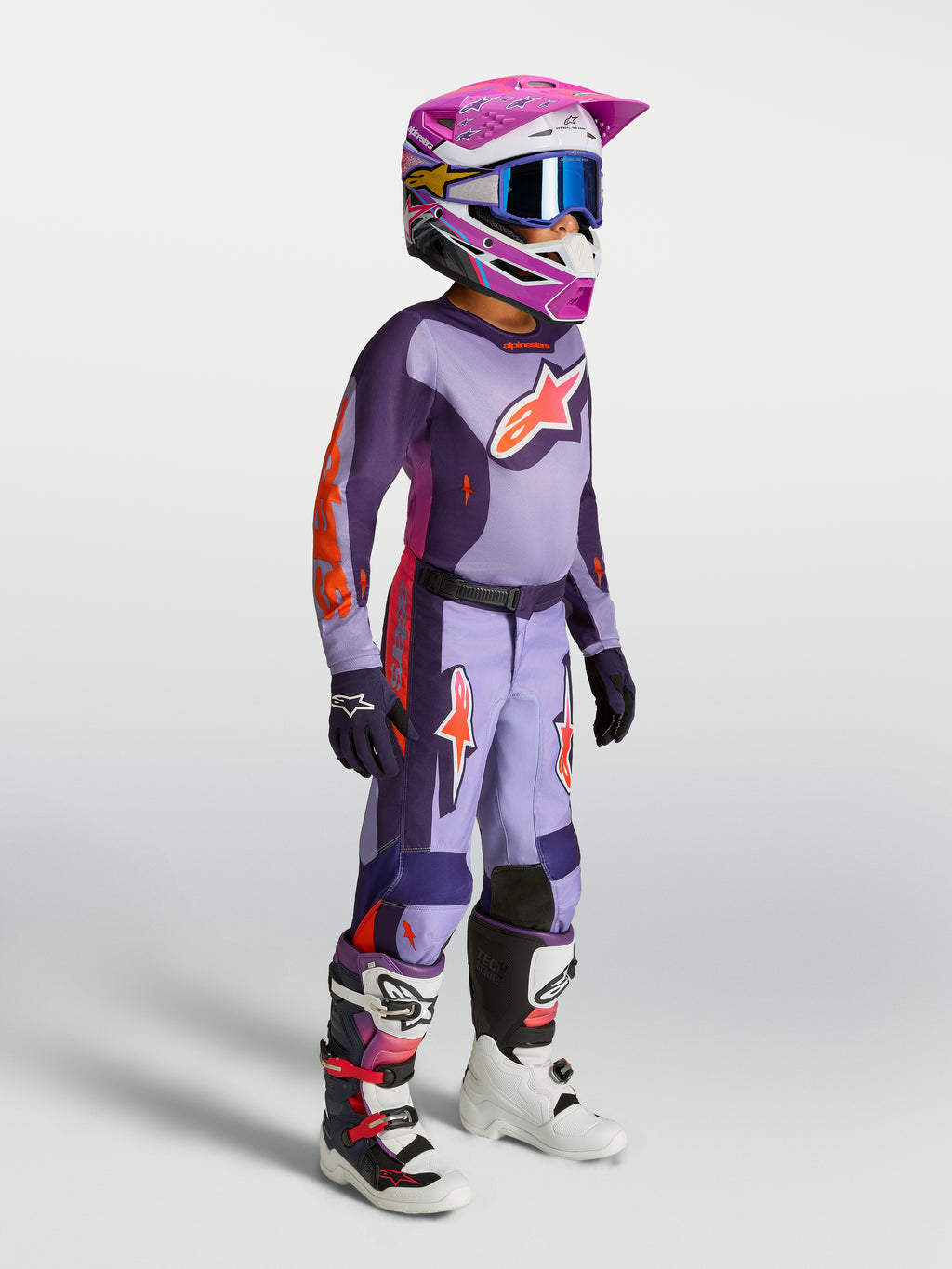 Młodzieżowy zestaw Alpinestars 2027 Fluid Hunt, fioletowy i różowy fluo, koszulka i spodnie motocrossowe na modelu.